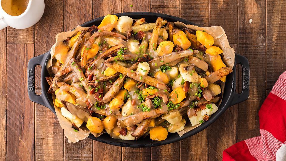 Φωτογραφία από καναδικό poutine με τηγανητές πατάτες, τυρί, μπέικον και σάλτσα.