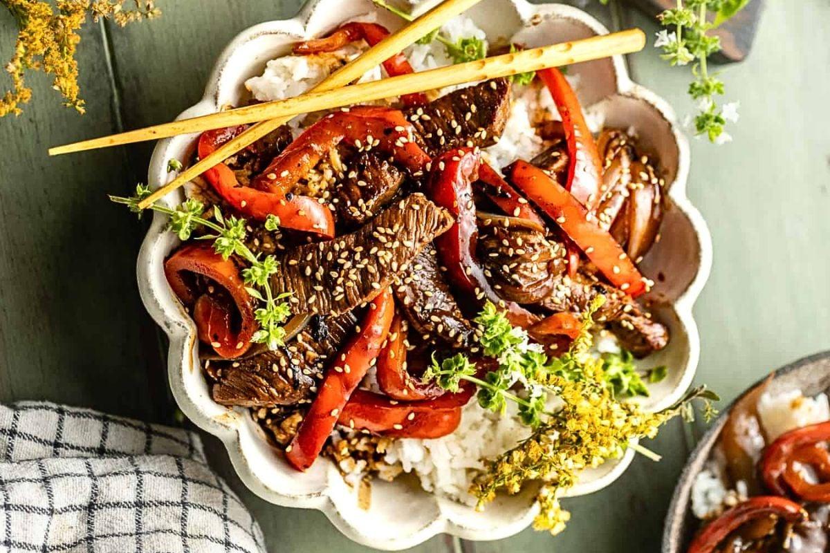 Εύκολο Δείπνο με Γουόκ: 18 Συνταγές Stir-Fry 11 Μοσχαρίσια μπριζόλα με πιπεριές stir fry πάνω από ρύζι, σε μπολ.
