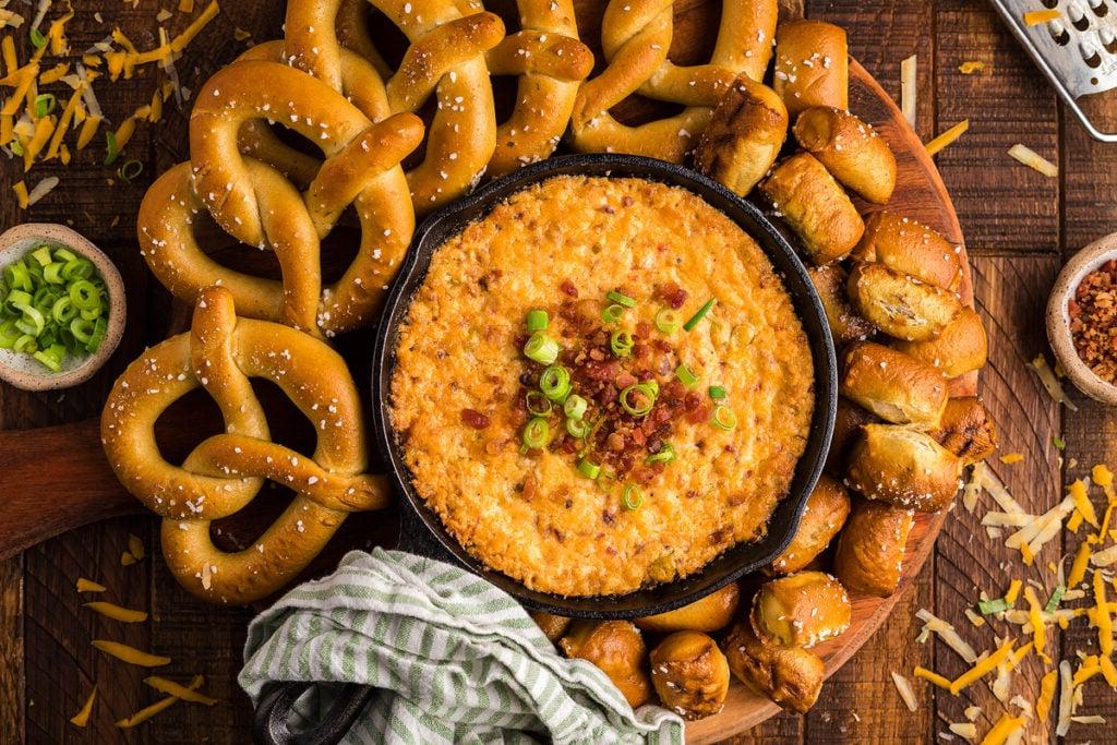 Άποψη από πάνω του καπνιστού dip τυριού gouda, μπέικον και cheddar με πρέτσελς.
