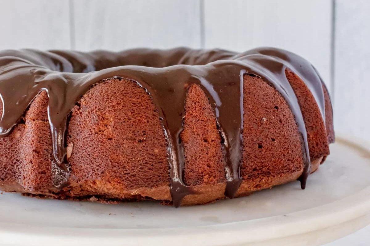 Σοκολατένιο κέικ bundt με γυαλιστερή γκανάς και μπράουνις σε λευκό πιάτο.