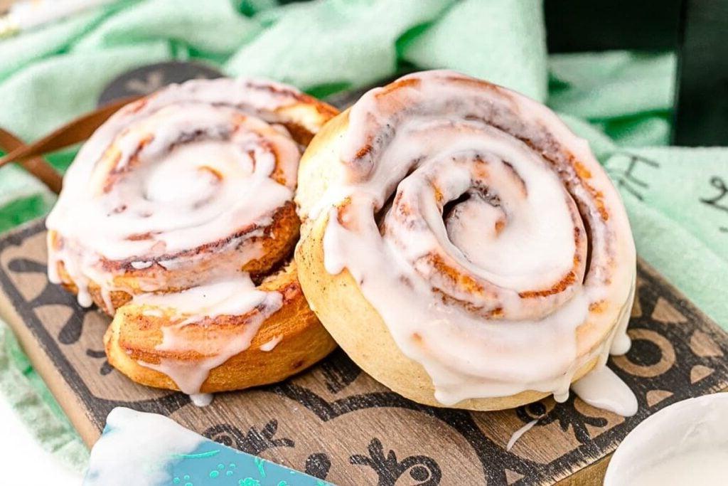 13 Νόστιμες Συνταγές για Ρολά Κανέλας Pillsbury που Πρέπει να Δοκιμάσετε Άμεσα 13 Two cinnamon rolls on a board with frosting.