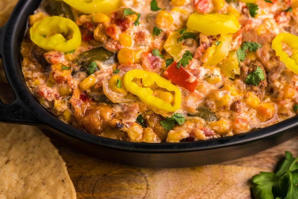 Ένα μαύρο πιάτο κατσαρόλας με dip taco.