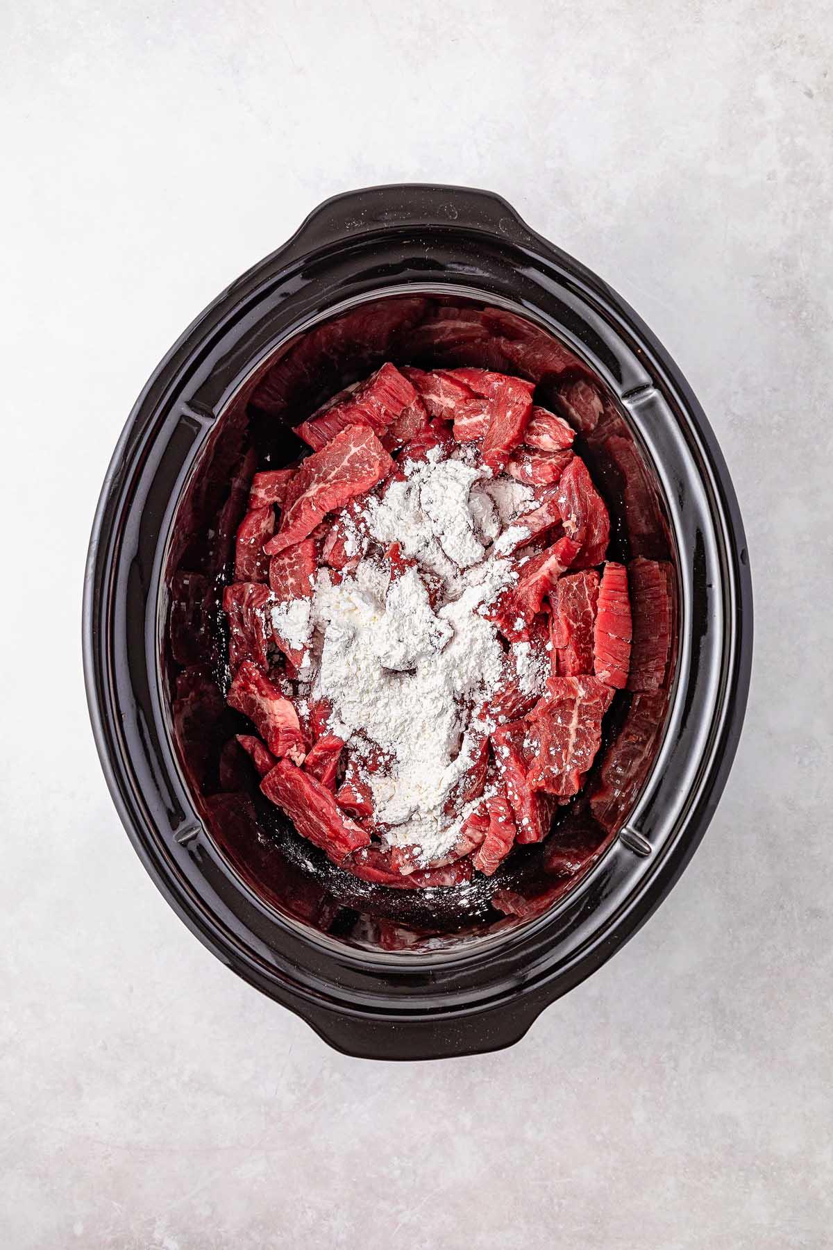 **Σιγομαγειρεμένο Μογγολικό Βοδινό** 14 Sliced beef mingles with rich Mongolian seasoning, nestled in the slow cooker, ready for a delicious culinary adventure.