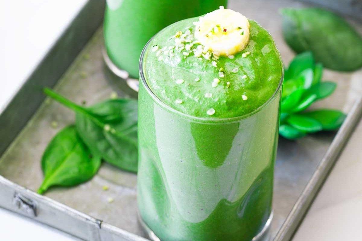 27 Εύκολες Συνταγές Smoothie για να Κάνουν την Ημέρα σας Καλύτερη 14 Δύο ποτήρια πράσινου smoothie σε δίσκο με συνταγές pinwheel.