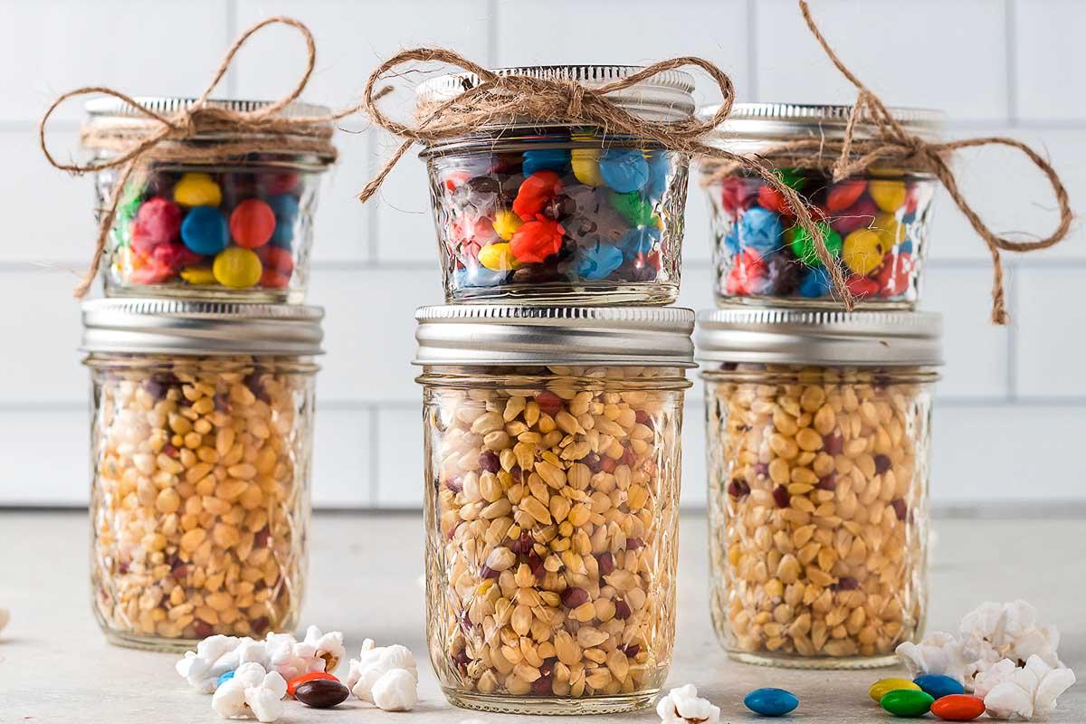 Ποπ κορν με M&M και Σοκολάτα – Σετ Δώρου DIY 16 Πέντε DIY κιτ δώρου ποπ κορν σε βάζα mason γεμάτα με ποπ κορν και καραμέλες.
