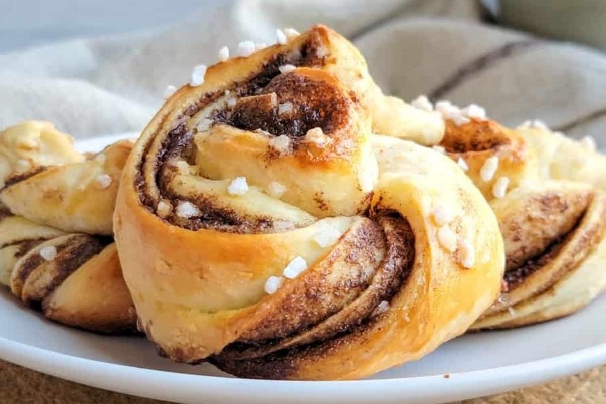 21 Πραγματικά Λαχταριστές Συνταγές για Σαλιγκάρια Κανέλας 18 Νόστιμα κανελοψωμάκια σε πιάτο με πετσέτα.