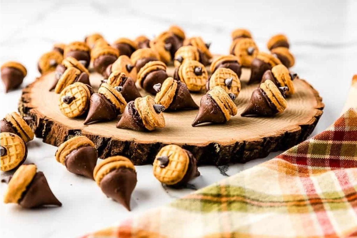 21 Λαχταριστές Συνταγές με σοκολάτα Hershey's Kiss 18 Ένα πιάτο με βελανίδια από συνταγές Hershey Kiss σε ένα ξύλινο κομμάτι κοπής.