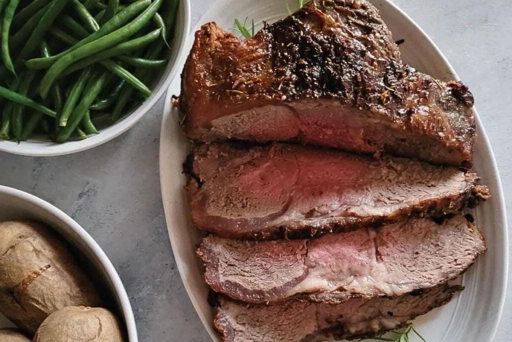 Ένα ψητό New York strip, κομμένο σε φέτες σε πιατέλα σερβιρίσματος.