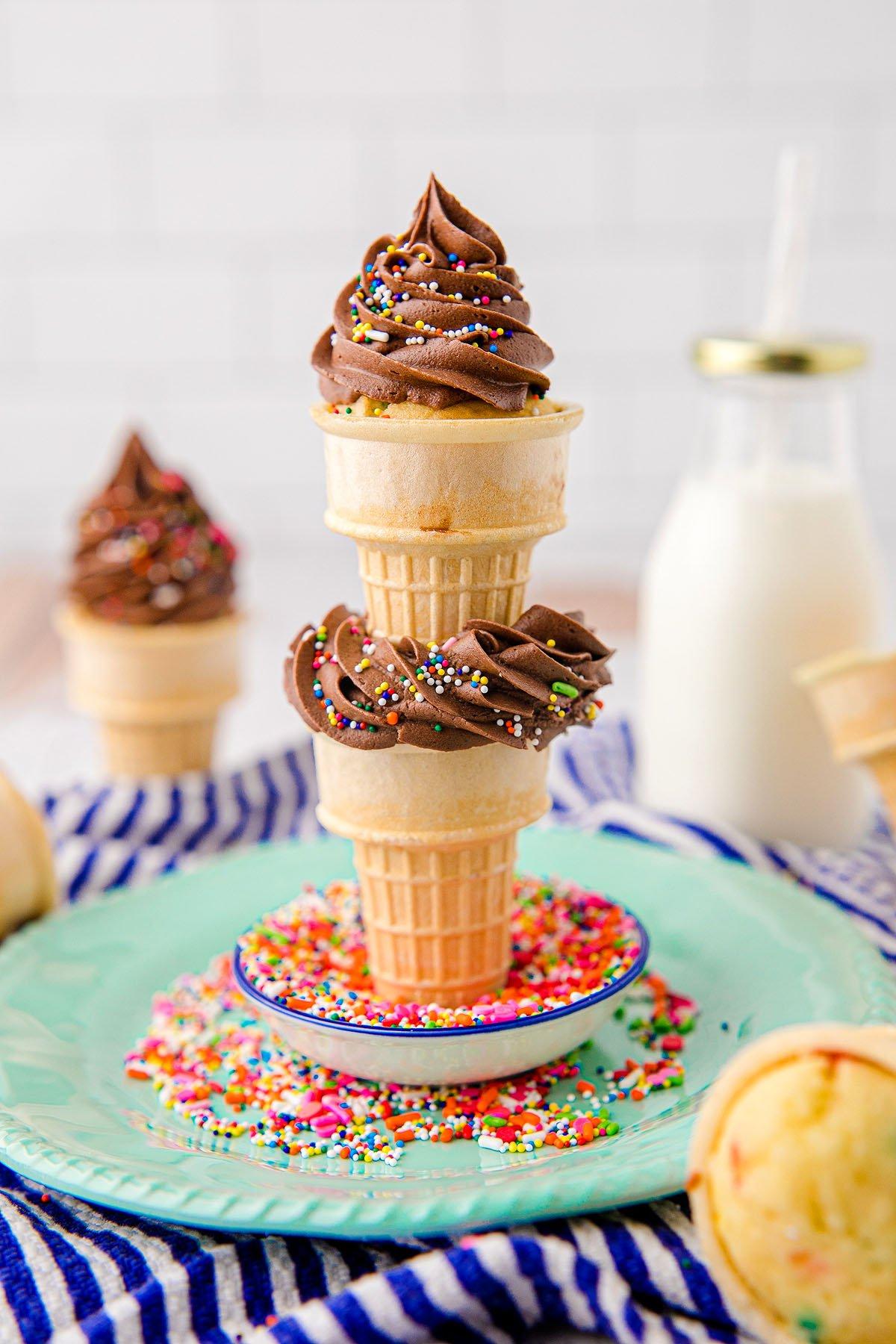 Κεκάκια Χωνάκι Παγωτού 3 Τρία cupcakes σε χωνάκι παγωτού με σοκολατένια βουτυρόκρεμα και πολύχρωμη τρούφα είναι στοιβαγμένα σε ένα πιάτο – τέλεια cupcakes για πάρτι γενεθλίων που σίγουρα θα ενθουσιάσουν τους καλεσμένους όλων των ηλικιών.