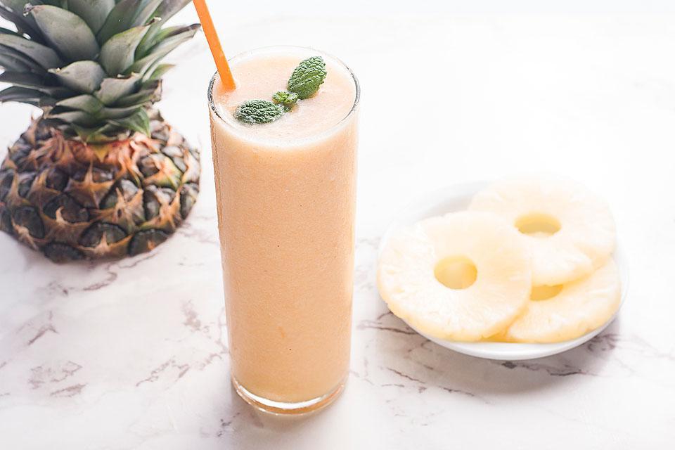 27 Εύκολες Συνταγές Smoothie για να Κάνουν την Ημέρα σας Καλύτερη 3 Ένα φρέσκο smoothie ανανά-ροδάκινου με καλαμάκι και μια φέτα ανανά.