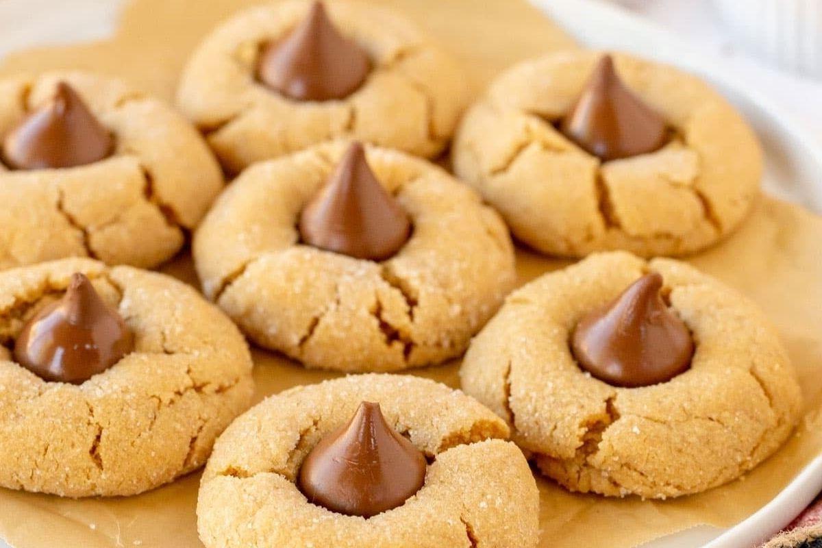 21 Λαχταριστές Συνταγές με σοκολάτα Hershey's Kiss 3 Μπισκότα φυστικοβούτυρου με Hershey Kiss σε ένα πιάτο, κλασικά και λαχταριστά.