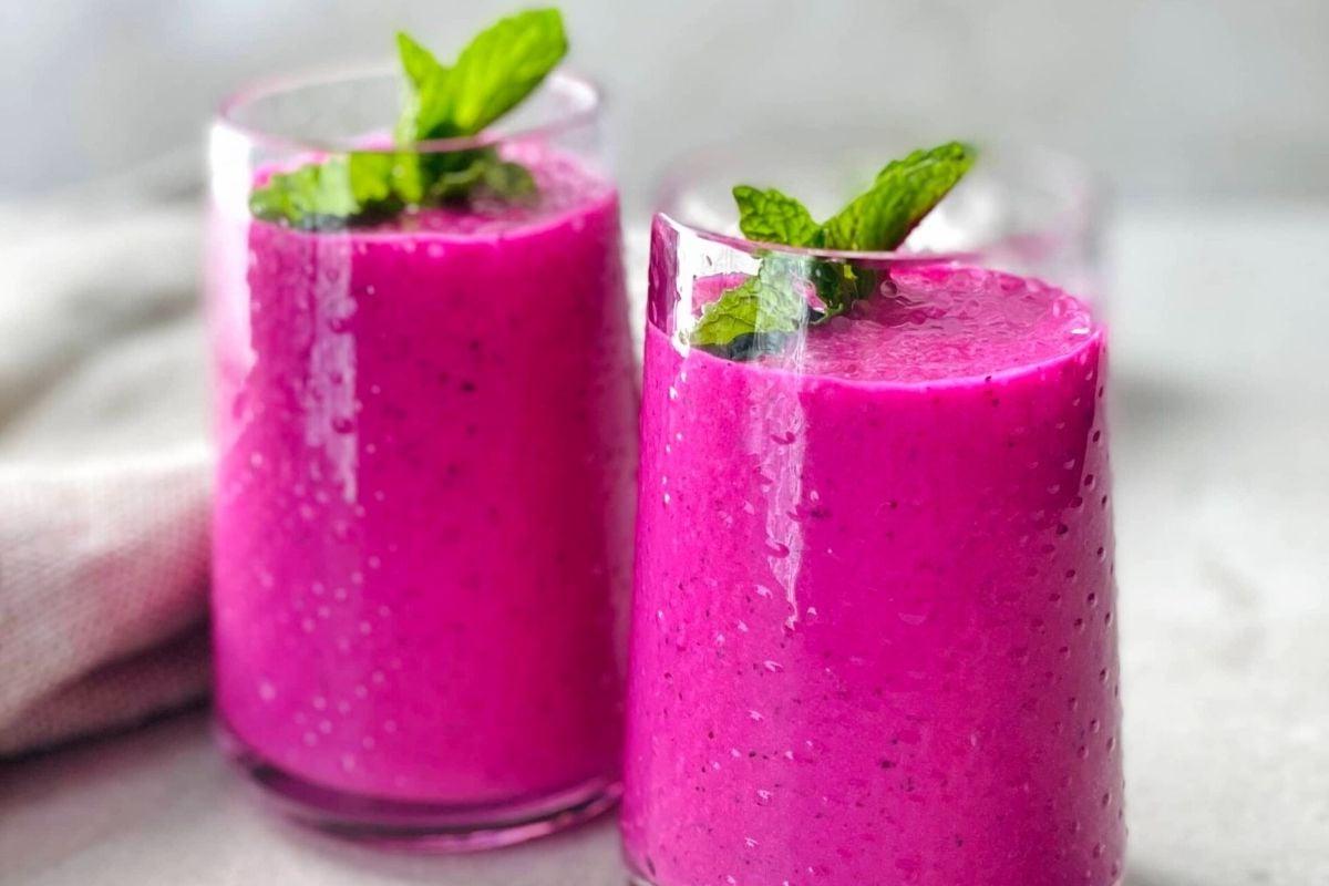 27 Εύκολες Συνταγές Smoothie για να Κάνουν την Ημέρα σας Καλύτερη 23 Δύο ποτήρια ροζ smoothie με φύλλα μέντας και συνταγές pinwheel.