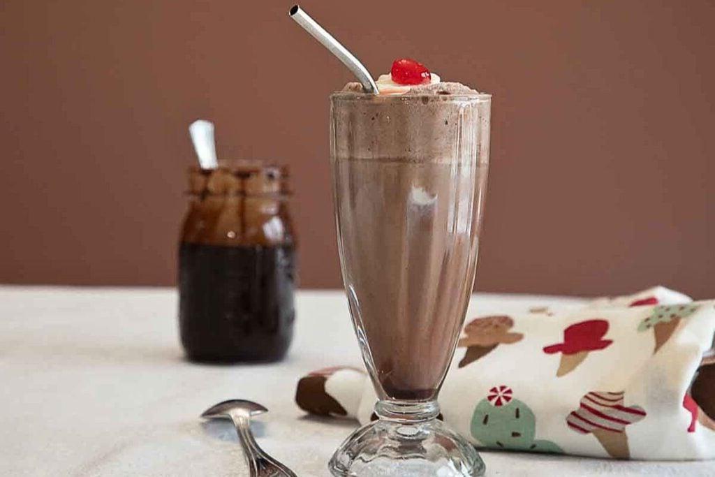 Ένα ψηλό ποτήρι σοκολατένια ice cream soda με καλαμάκι.