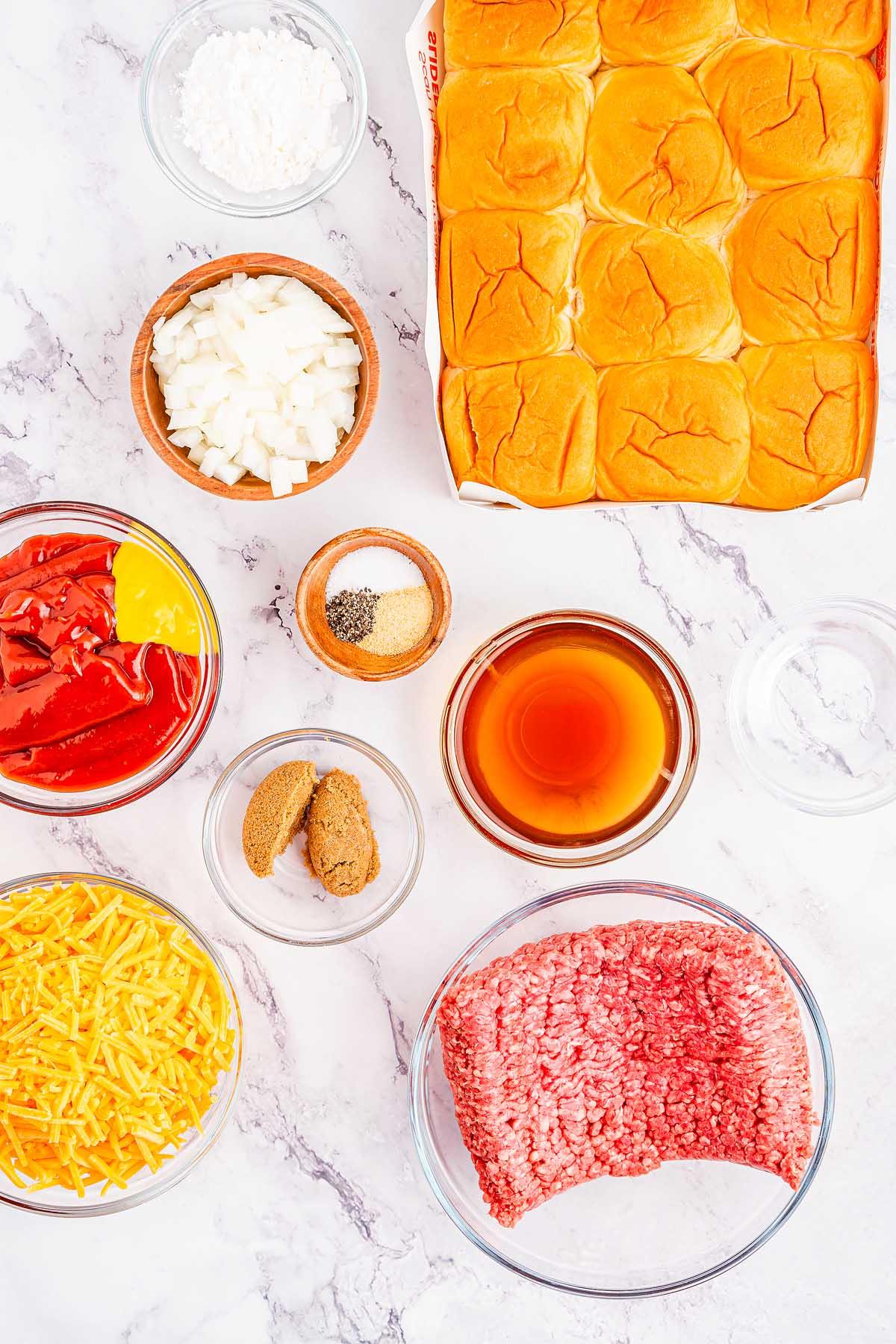 Σλόπι Τζο Μίνι Σάντουιτς 5 Υλικά για νόστιμα Sloppy Joe sliders τοποθετημένα σε μαρμάρινη επιφάνεια, συμπεριλαμβανομένων ψωμιών slider, ψιλοκομμένων κρεμμυδιών, τριμμένου τυριού, κιμά, κέτσαπ, μουστάρδας, καστανής ζάχαρης, σάλτσας Worcestershire, κορν φλάουρ, σκόνης σκόρδου, μαύρου πιπεριού και αλατιού.