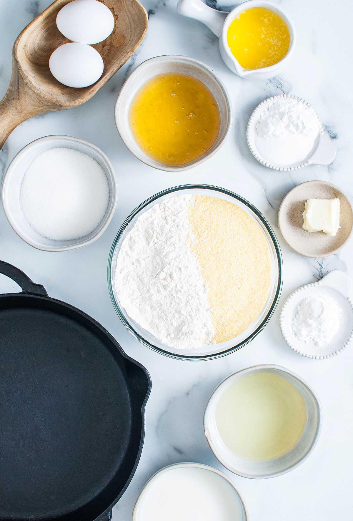 Γλυκό Καλαμποκόψωμο στο Τηγάνι 5 Η συνταγή για ένα γλυκό ψωμί καλαμποκιού σε μαντεμένιο τηγάνι, ψημένο με μέλι, σερβιρισμένο σε μαρμάρινο τραπέζι.