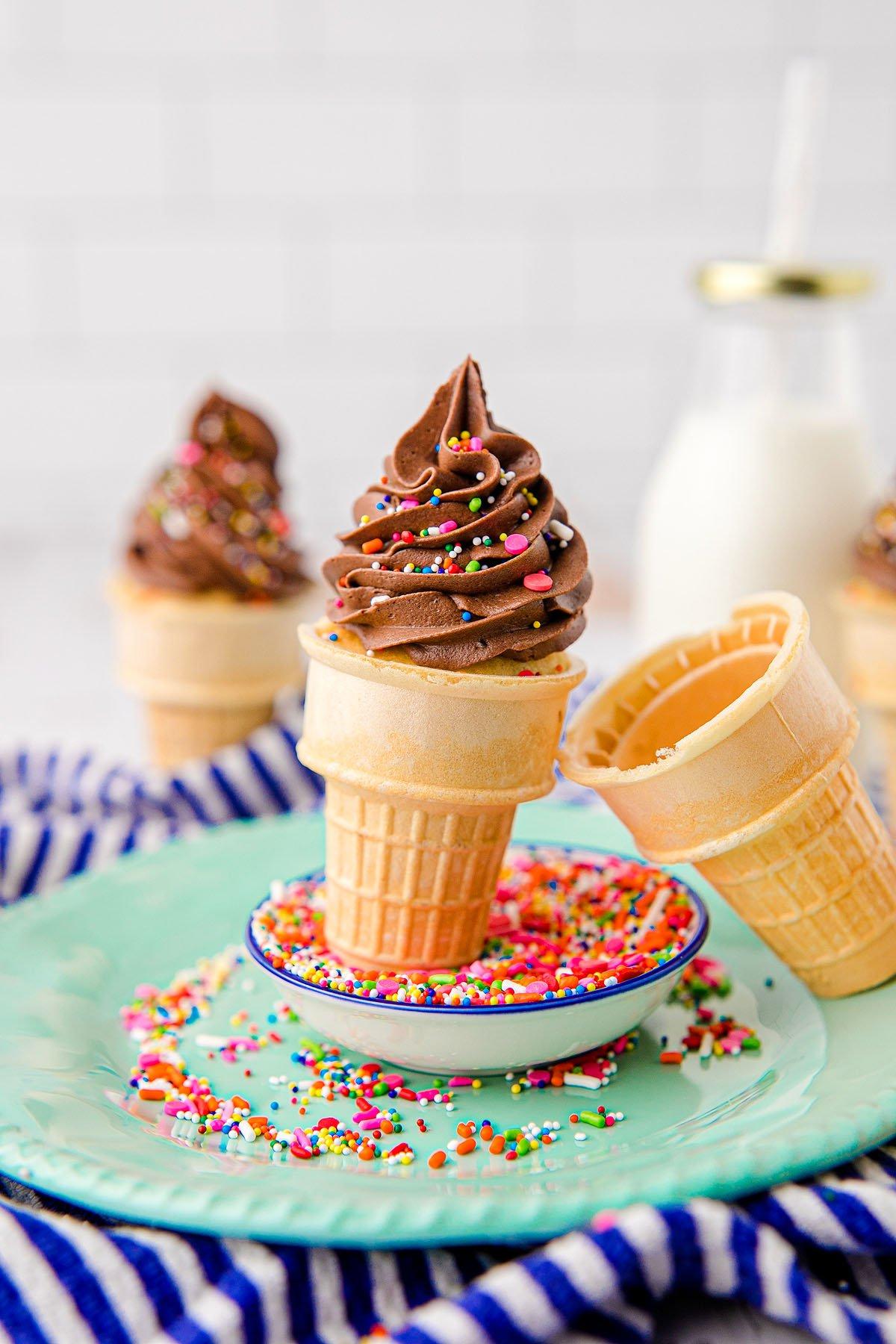 Κεκάκια Χωνάκι Παγωτού 8 Cupcakes με επικάλυψη σοκολάτας σε χωνάκια παγωτού με πολύχρωμη τρούφα σε πιάτο, και ένα μπουκάλι γάλα στο παρασκήνιο – τέλειες λιχουδιές εμπνευσμένες από το μείγμα funfetti για πάρτι γενεθλίων.