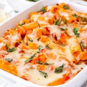 Πάστα στο φούρνο 12 Ένα λευκό ταψί γεμάτο με Pasta al Forno, ψητά τυρένια ζυμαρικά με λιωμένο τυρί και γαρνιρισμένο με βότανα.