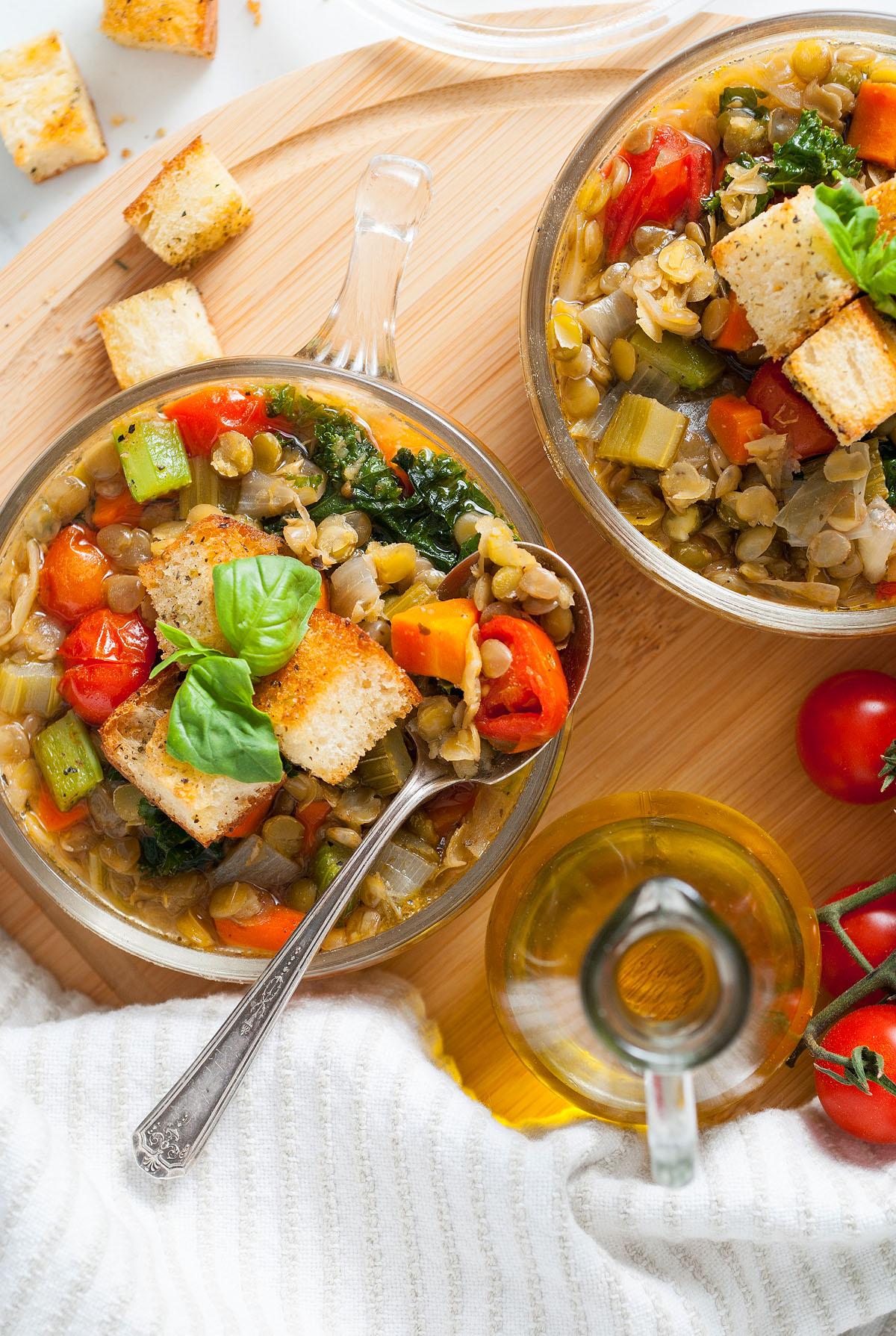 Ιταλική Σούπα Φακής 3 Δύο μπολ Zuppa Di Lenticchie, μια χορταστική μινεστρόνε φακής που ξεχειλίζει από φρέσκα λαχανικά, γαρνιρισμένα με κρουτόν και βασιλικό, με ντομάτες και ελαιόλαδο κοντά.