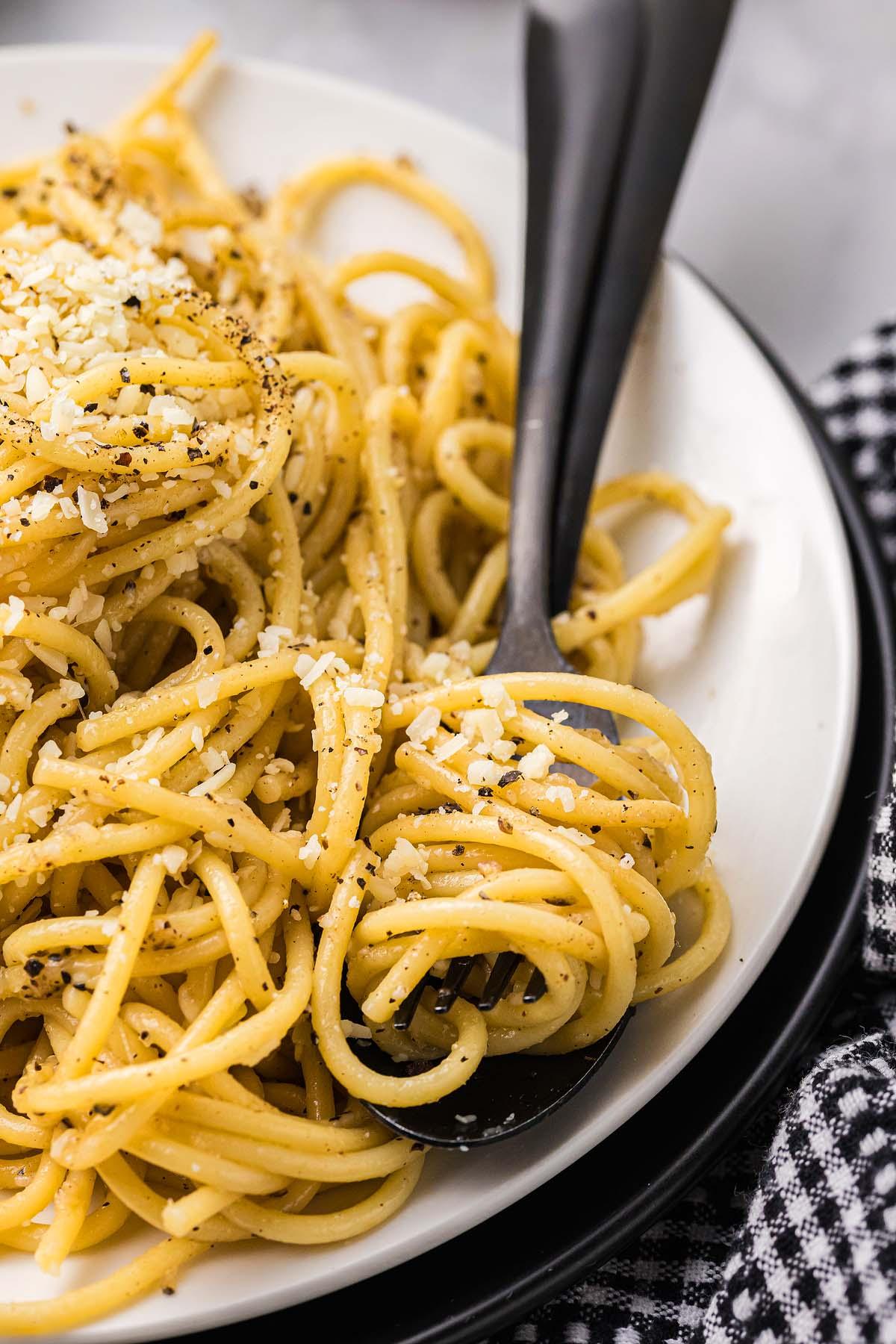 Τυρί και Πιπέρι 6 Ένα πιάτο κλασικό cacio e pepe, με τέλεια μαγειρεμένα σπαγγέτι διακοσμημένα με ψιλοτριμμένο τυρί και μια δόση μαύρου πιπεριού, σερβιρισμένο κομψά με ένα πιρούνι.