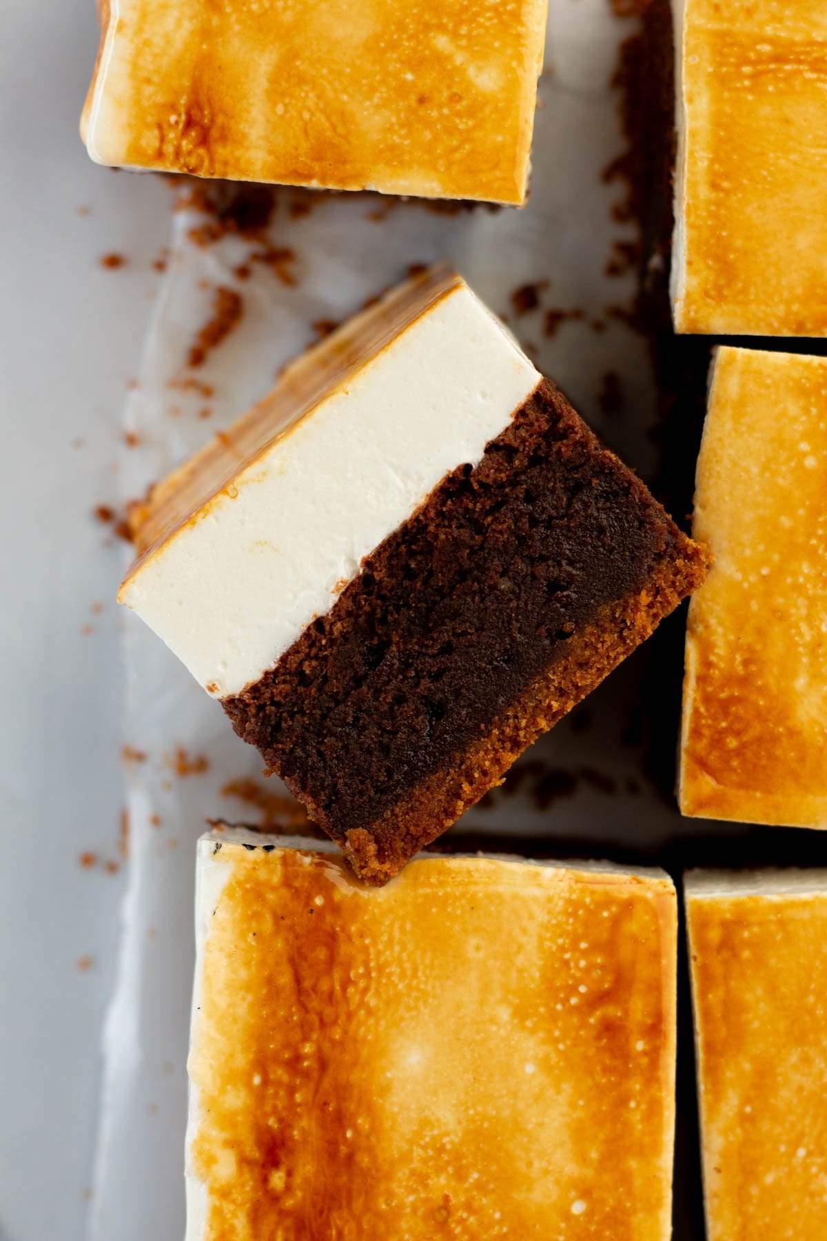 Κοντινό πλάνο κομμένων s'mores brownies. Κάθε κομμάτι έχει μια σκούρα καφέ βάση, μια μέση κρεμώδη στρώση και μια καστανή κορυφή.