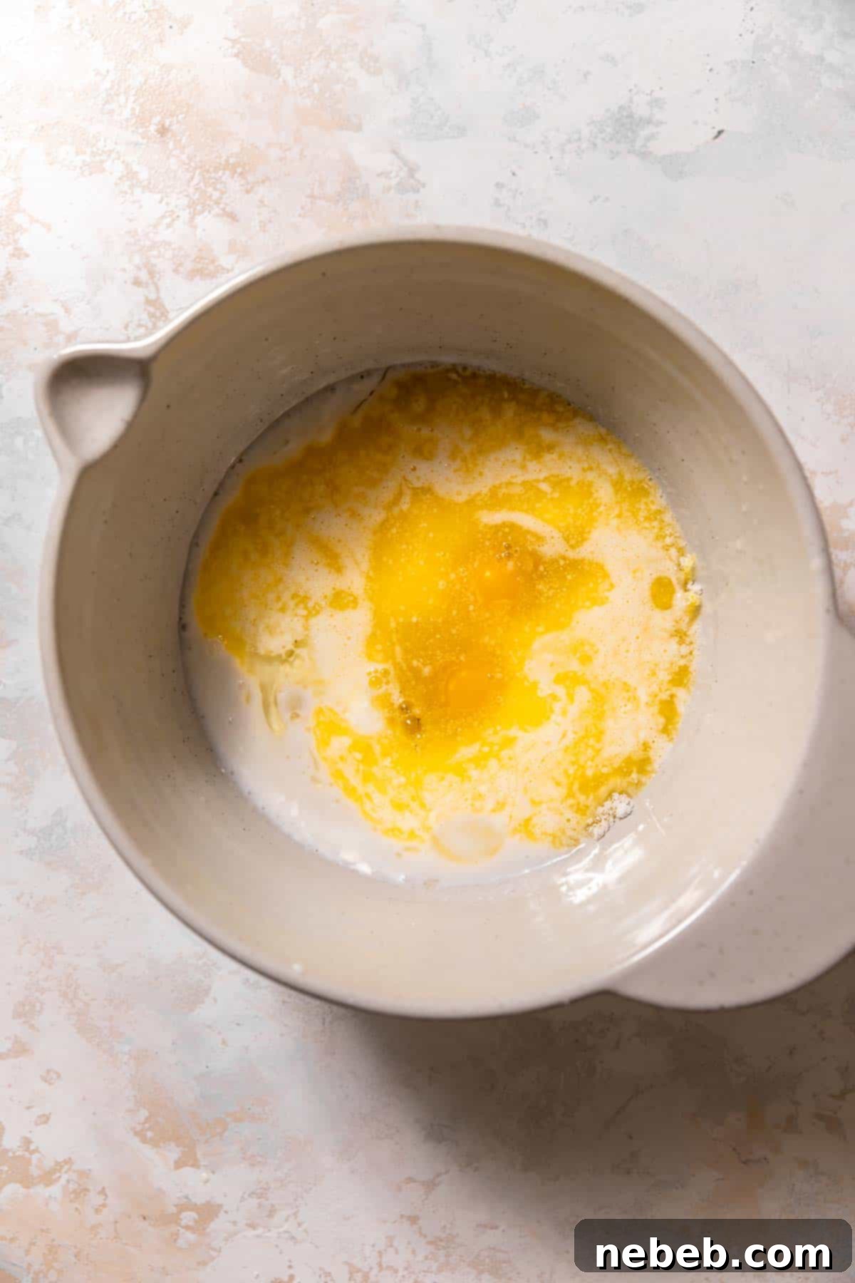 A mixing bowl with the wet ingredients for the lemon raspberry muffin batter, whisked together.