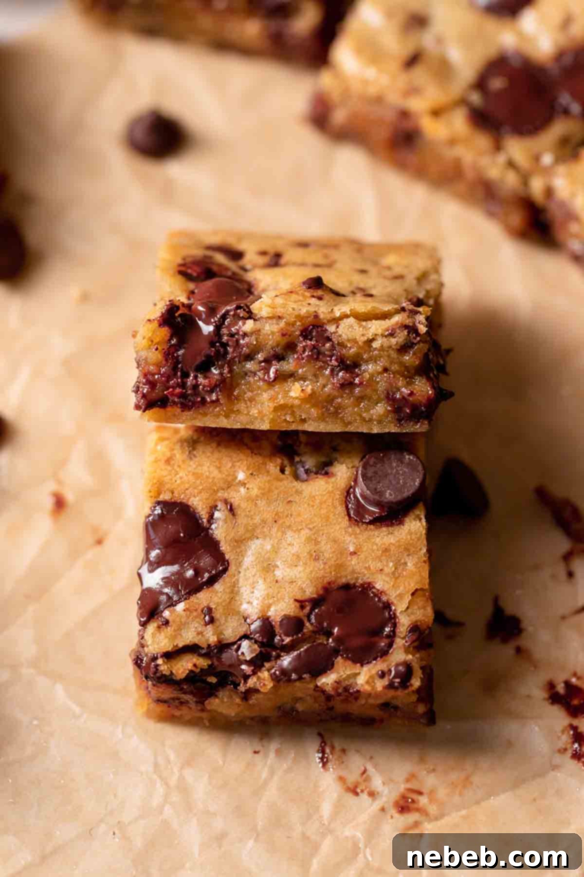 close-up of a chocolate chip blondie bar with chocolate chips scattered around it, showcasing its gooey texture.