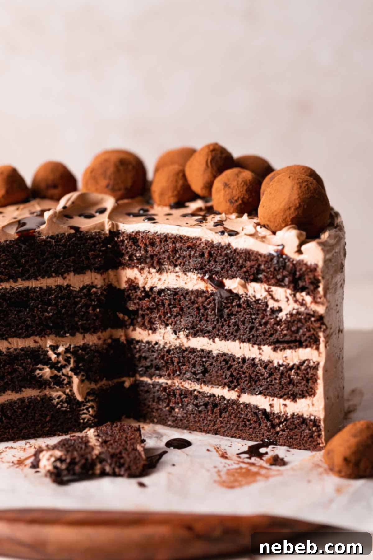 A beautifully moist chocolate coffee cake resting on a wooden cake board, showcasing its rich layers and tempting chocolate coffee syrup drizzle. Perfect for any celebration.