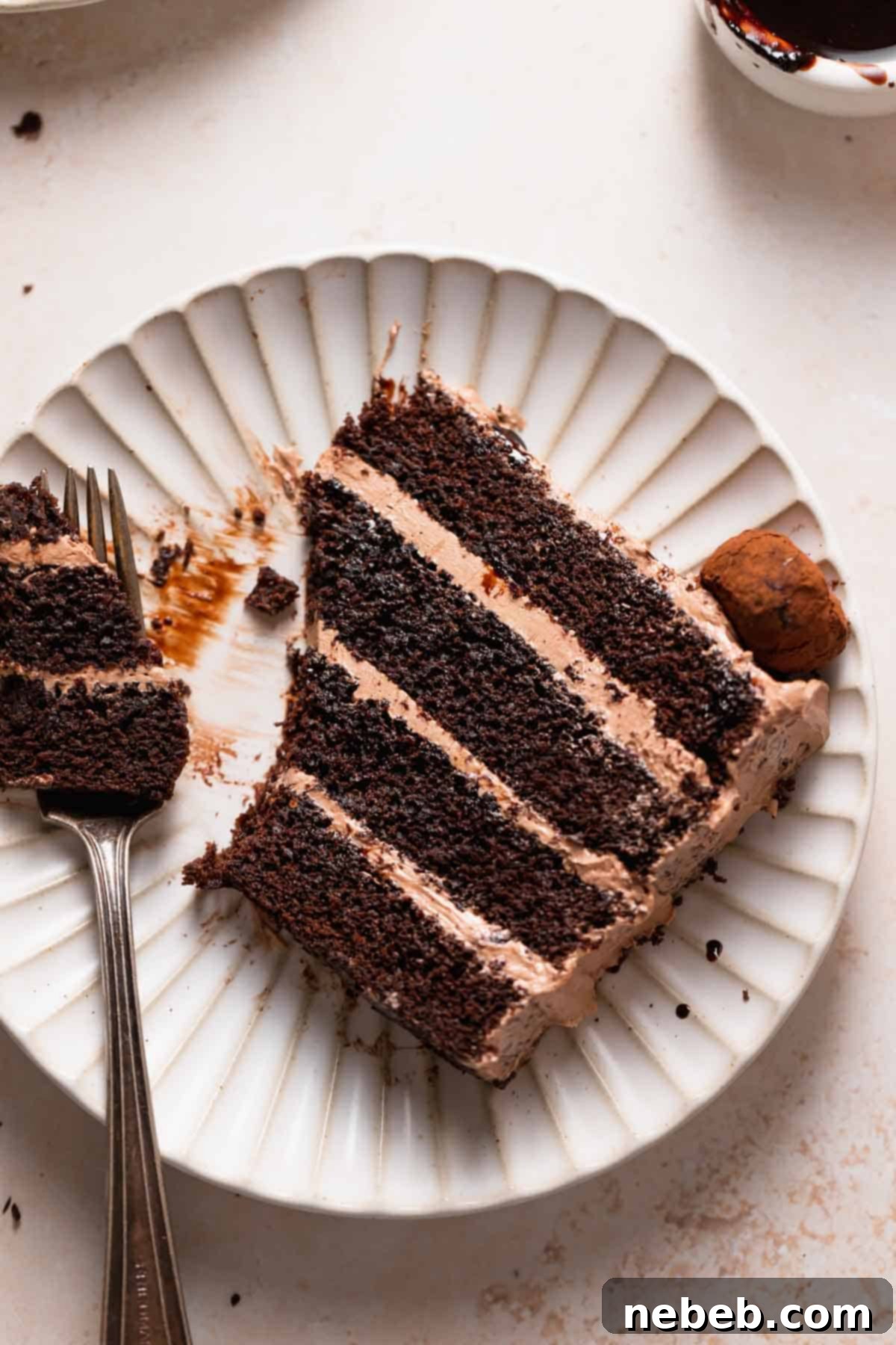 A delectable slice of moist chocolate coffee cake served on a pristine white plate, showcasing its fluffy texture, beautiful layers, and the delicate crumb. A perfect dessert portion.