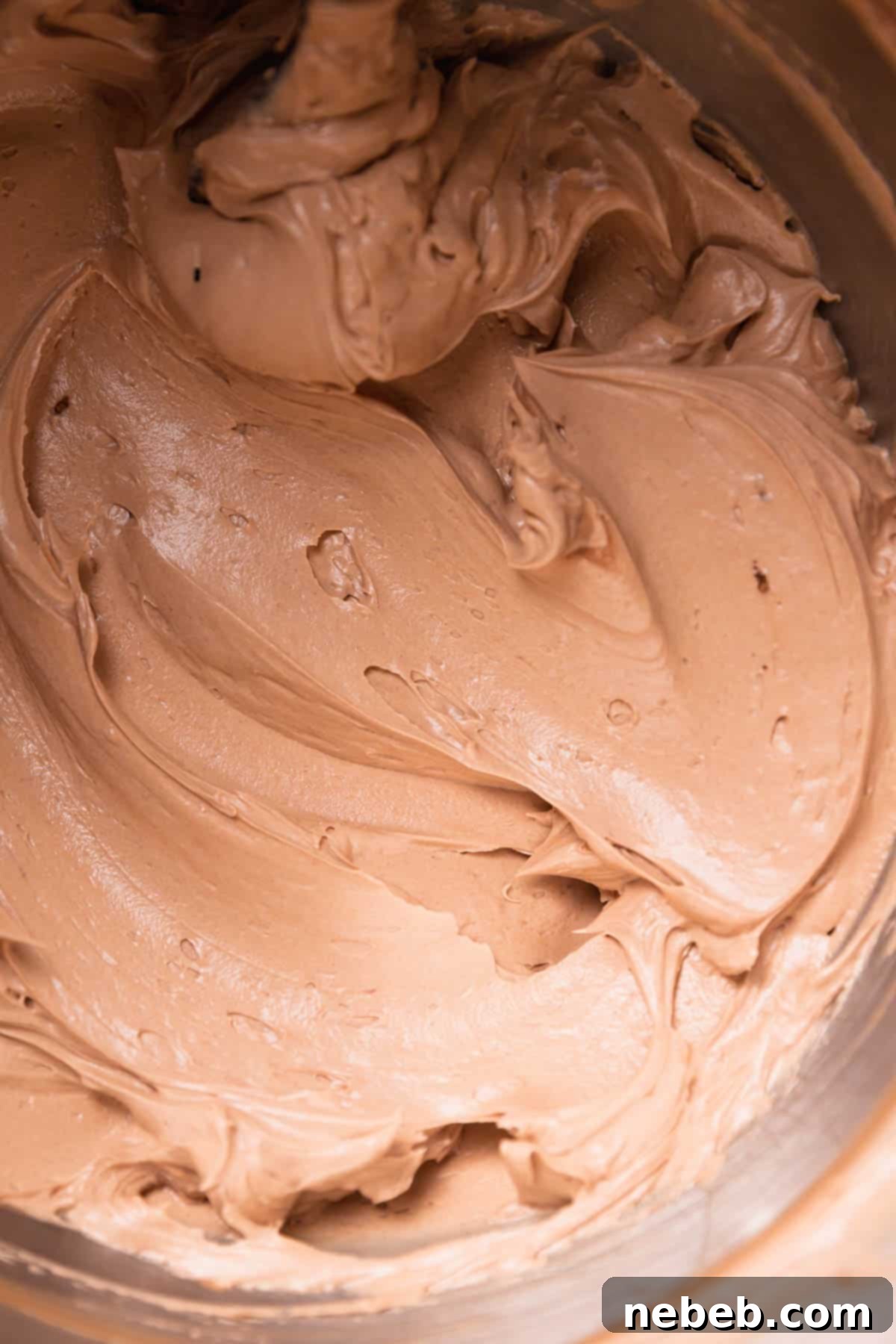 Lush, creamy chocolate coffee buttercream swirled in a mixing bowl, perfectly prepared and ready for frosting the decadent chocolate coffee cake.