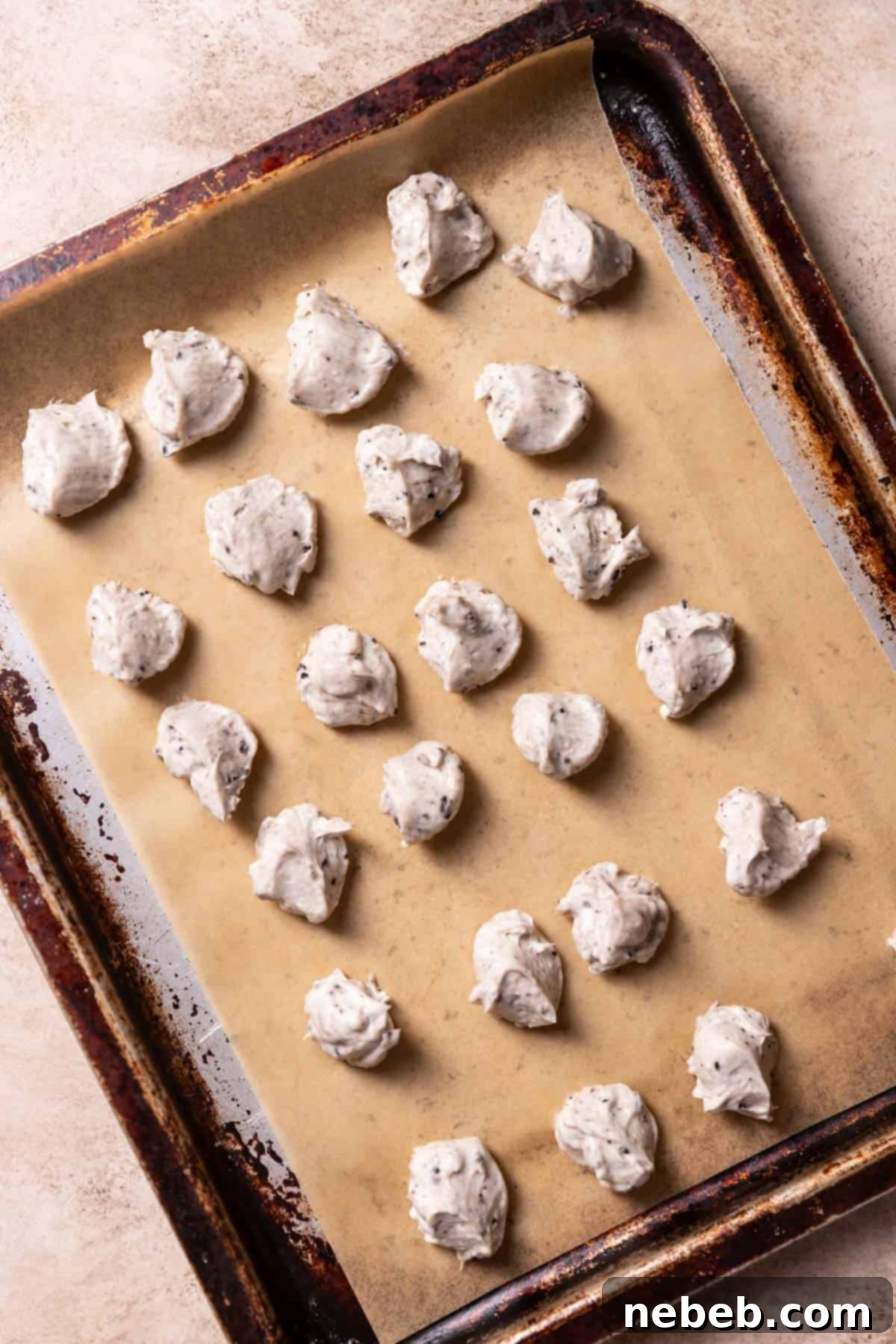 Balls of creamy cheesecake filling on a baking tray, ready for chilling.