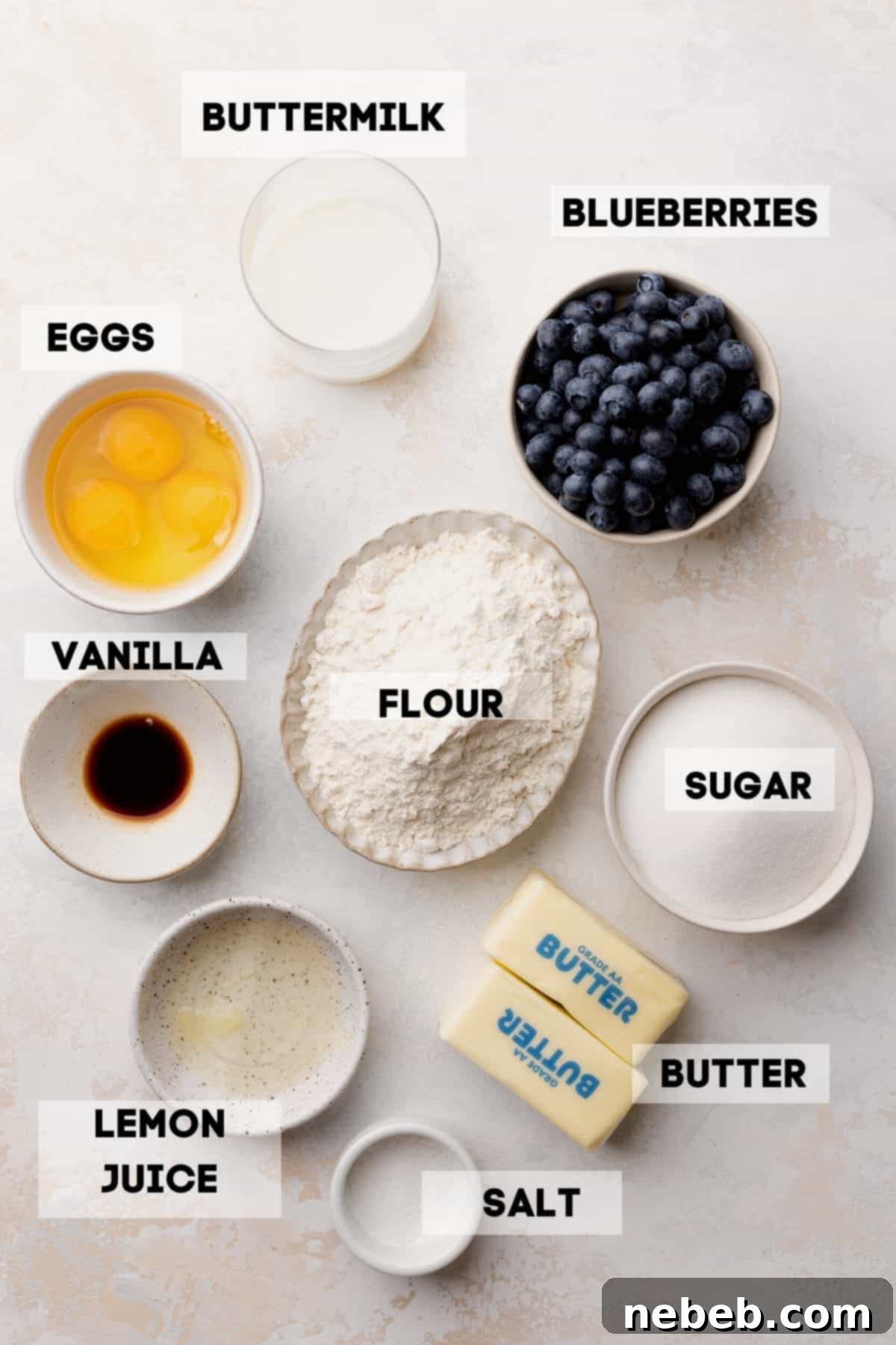 bowls of ingredients for blueberry cake, including fresh blueberries, flour, sugar, and butter, prepared for baking.