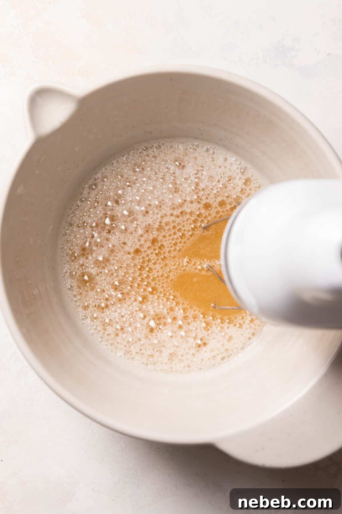 whisking the hot sugar syrup and gelatin in a mixing bowl.