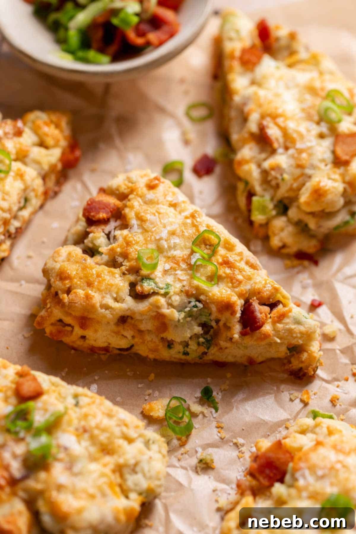 Savory bacon cheddar scones on parchment paper after baking.