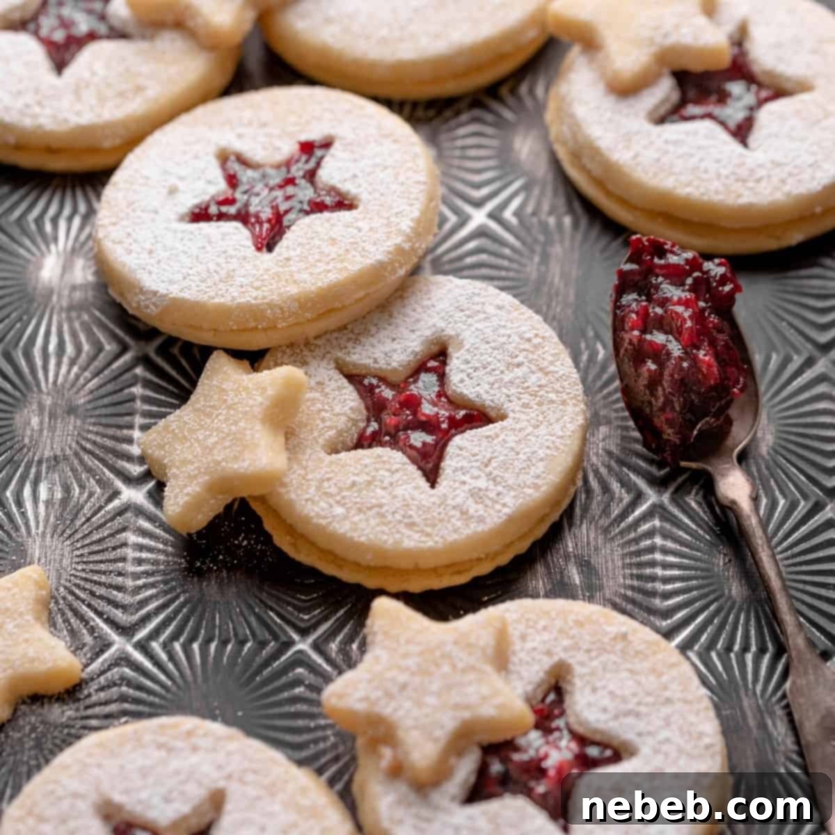 Close-up of a shortbread Linzer cookie with raspberry jam, dusted with powdered sugar, a perfect festive treat.