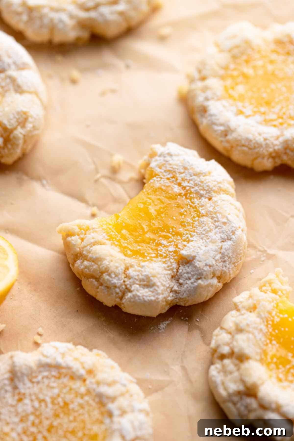 Simple Sunshine Lemon Squares 2 lemon bar cookies on parchment paper.