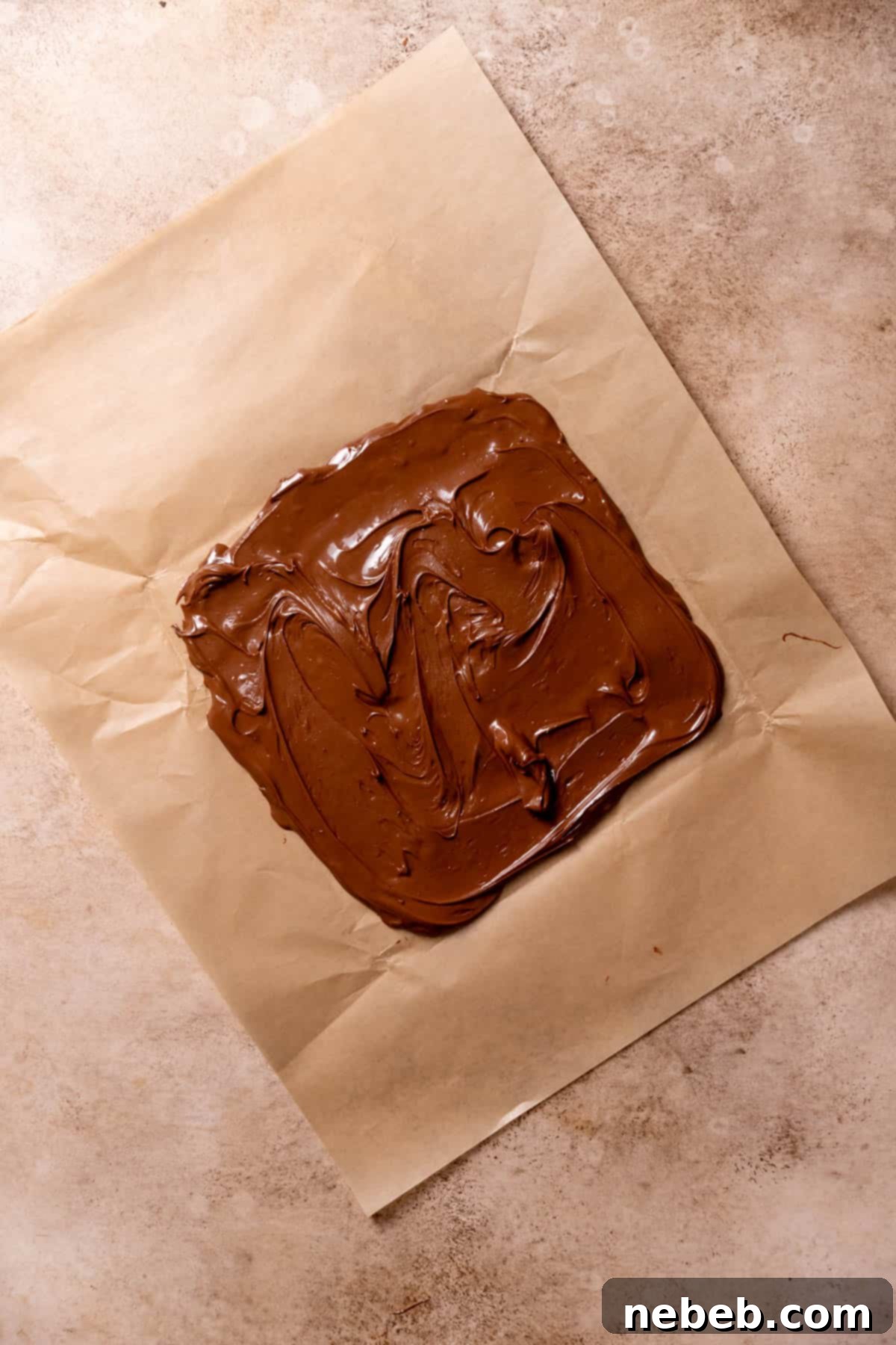 chocolate hazelnut spread smeared into a square on parchment paper.