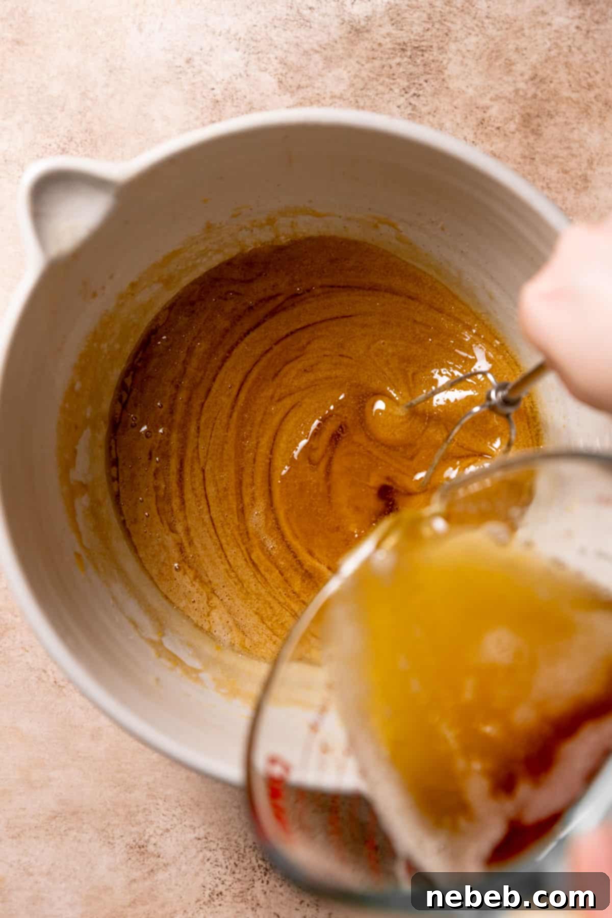 whisking the brown butter into the wet ingredients in a mixing bowl.