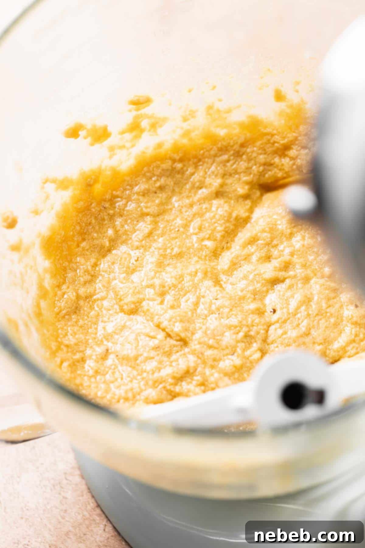 A stand mixing bowl with the creamed butter, sugar, and eggs mixed together.