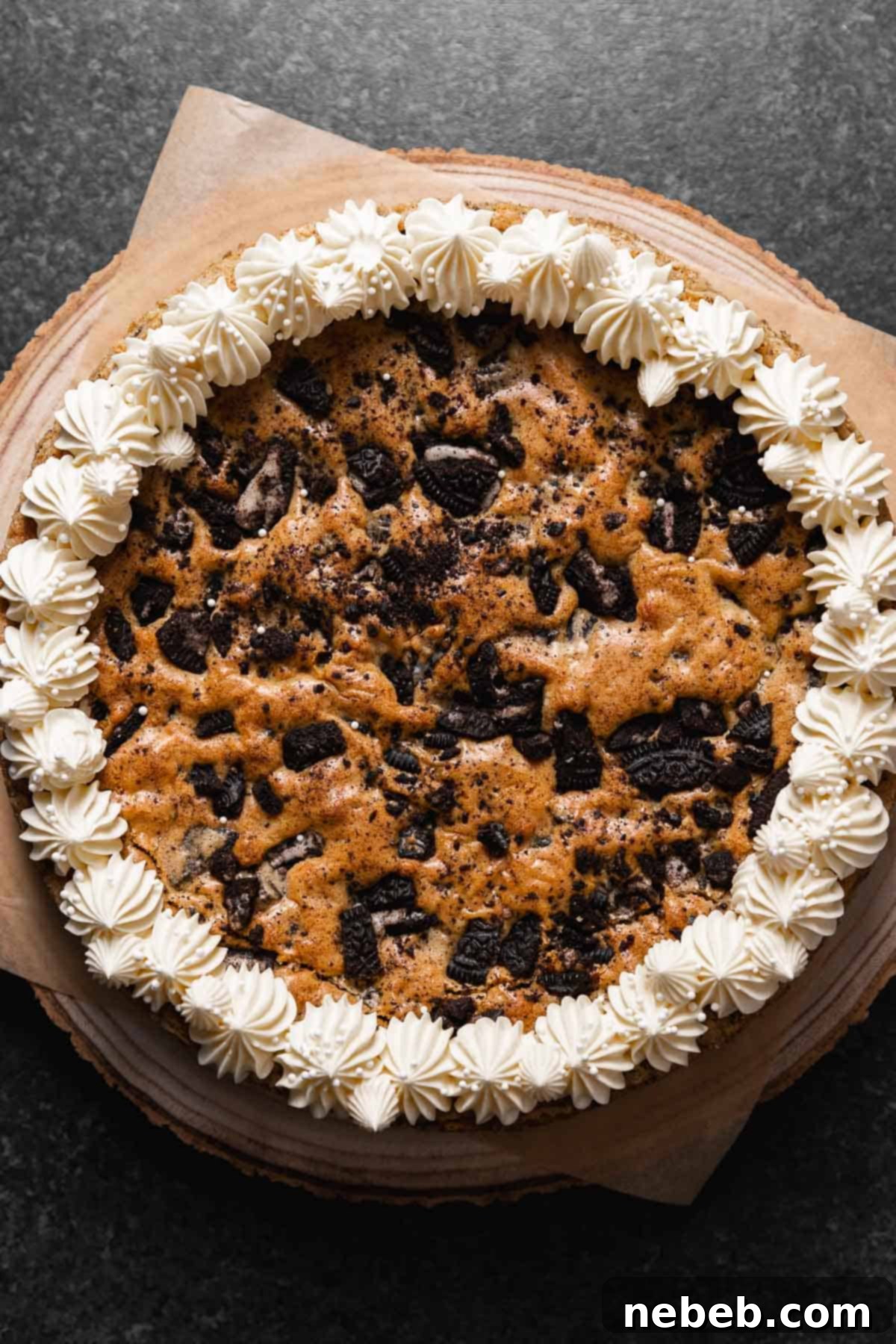 Oreo cookie cake decorated with vanilla frosting around the border.