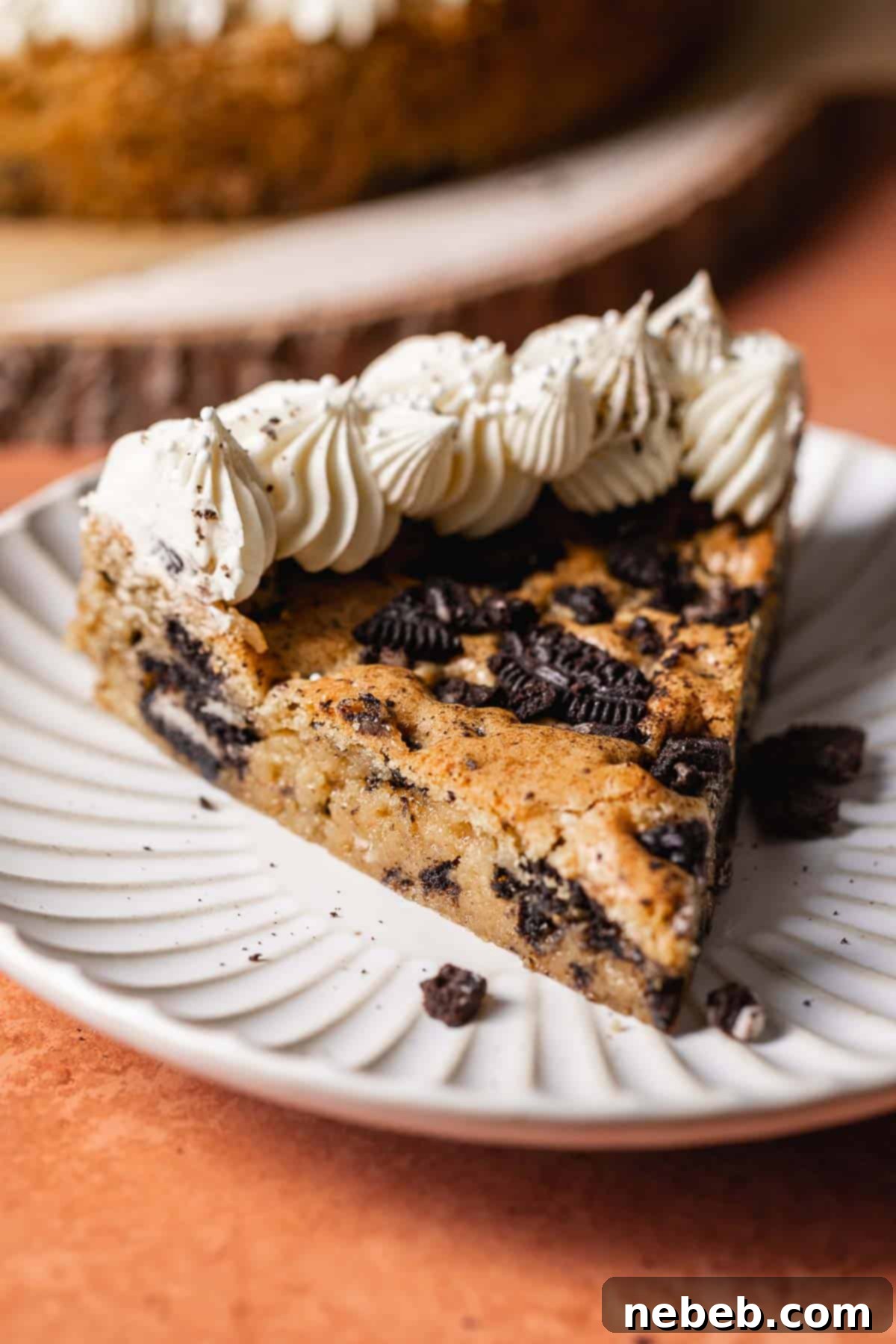 A slice of Oreo cake on a while plate.