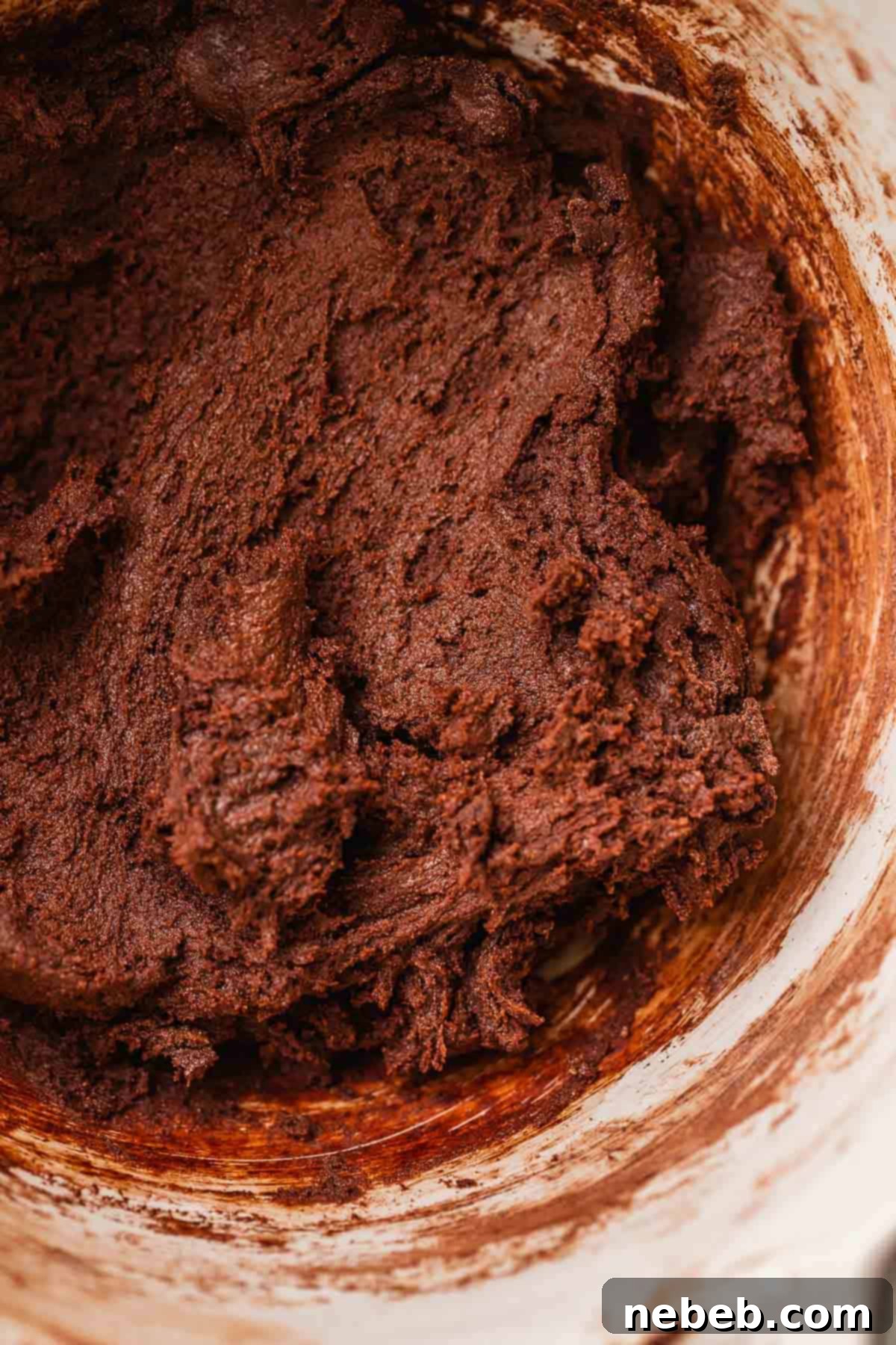 Rich, dark chocolate cookie dough in a mixing bowl, perfectly combined.