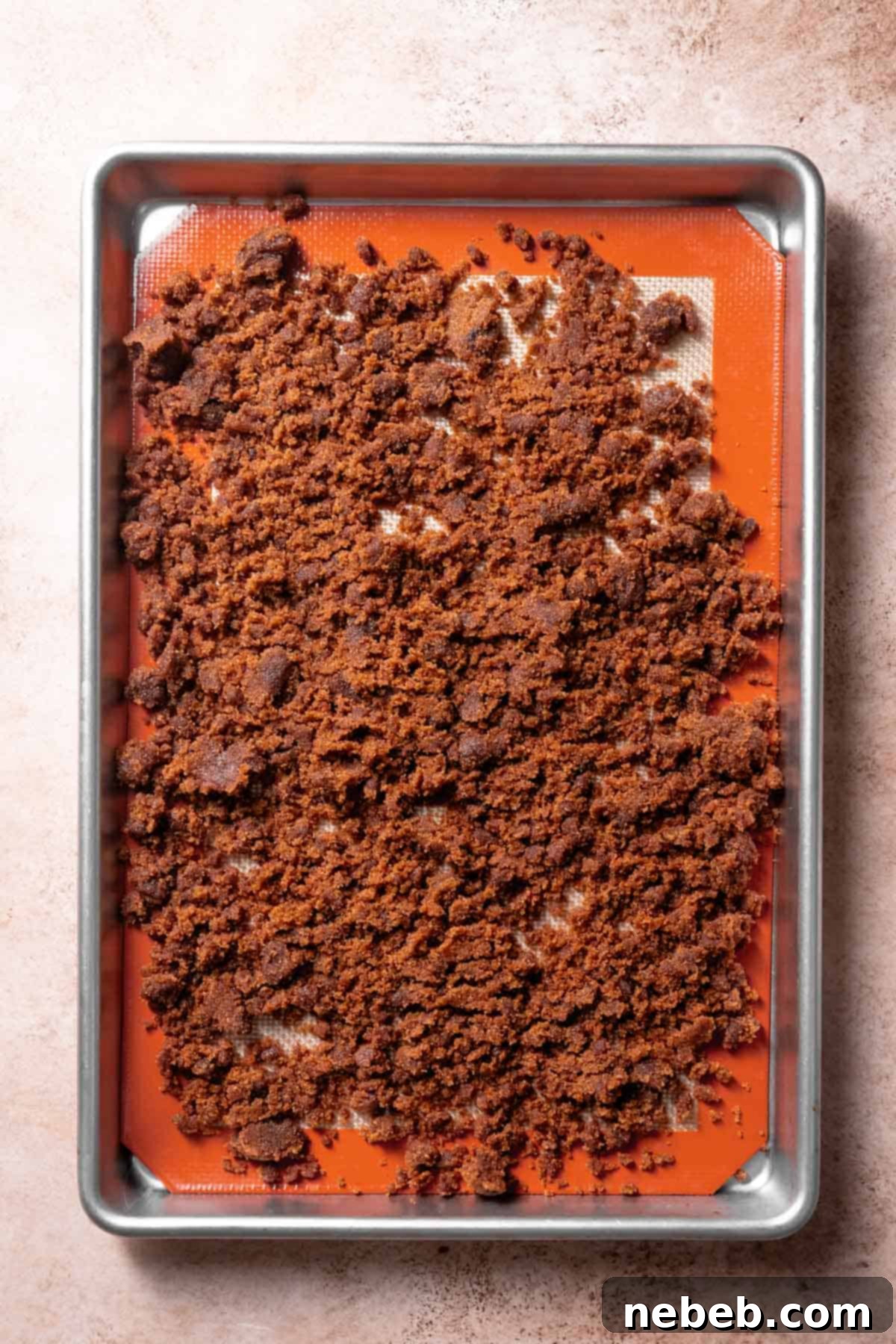 A baking pan with the cinnamon sugar crumb spread out on it.