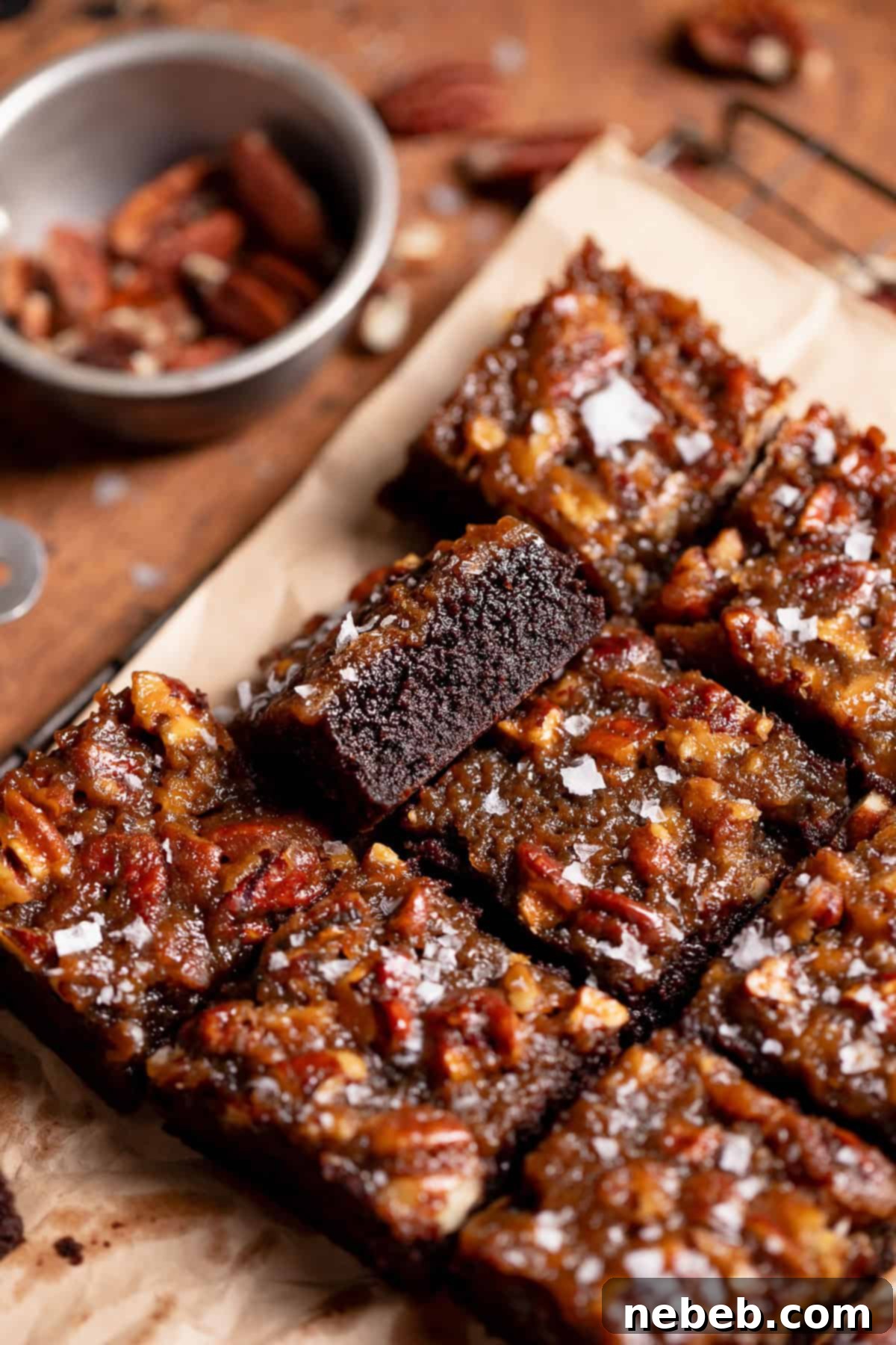 Pecan pie topped brownies cut into bars, showcasing the fudgy brownie base and the gooey pecan filling.