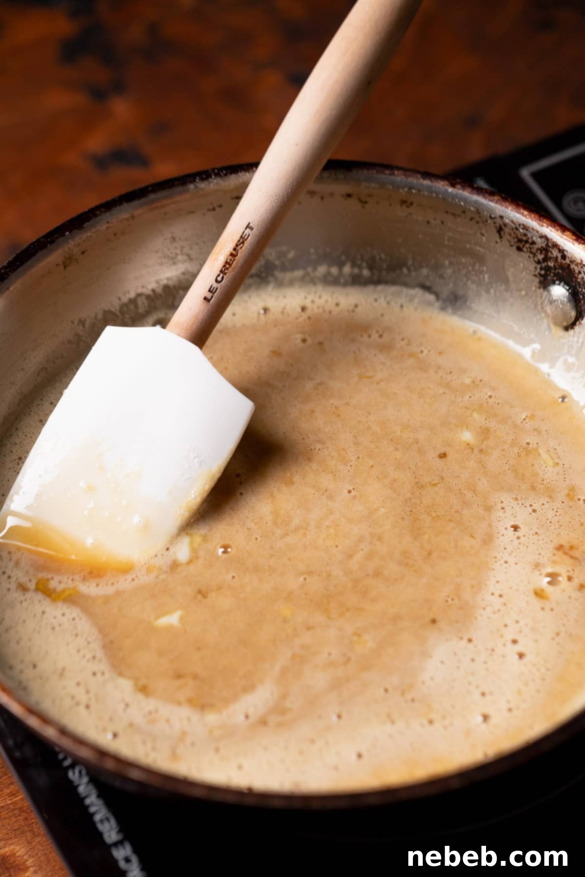A saucepan on the stove with the pecan pie filling simmering and thickening.