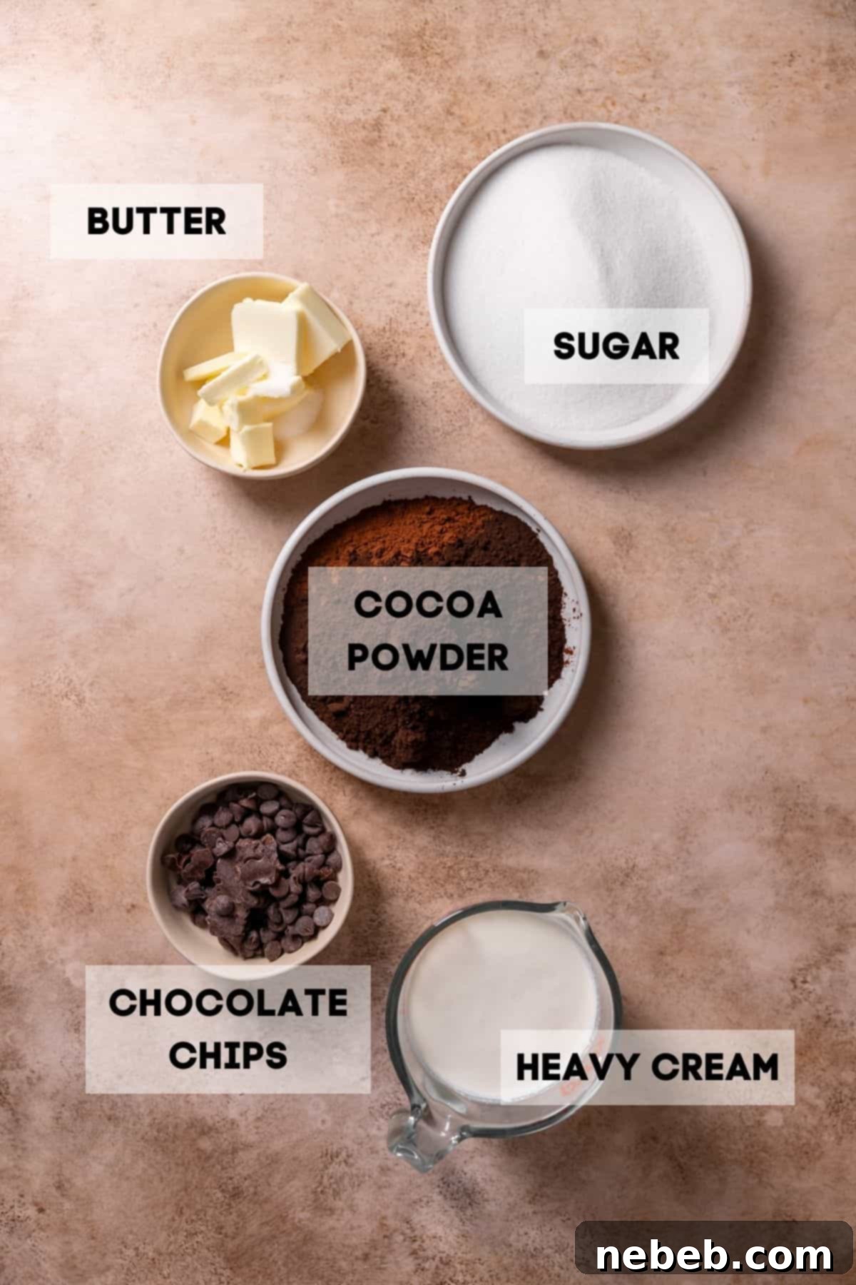Ingredients needed to make black fudge frosting in bowls with labels, neatly arranged on a counter.