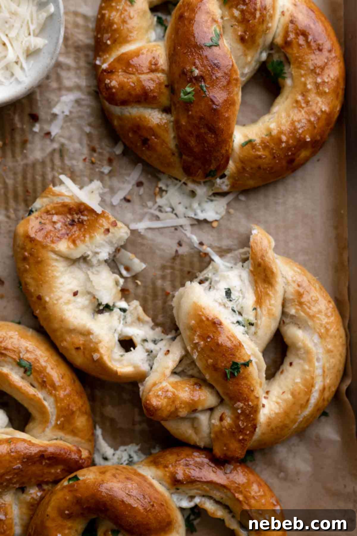 Creamy Spinach Artichoke Stuffed Pretzels 3 spinach artichoke stuffed pretzel ripped in half to show the filling.