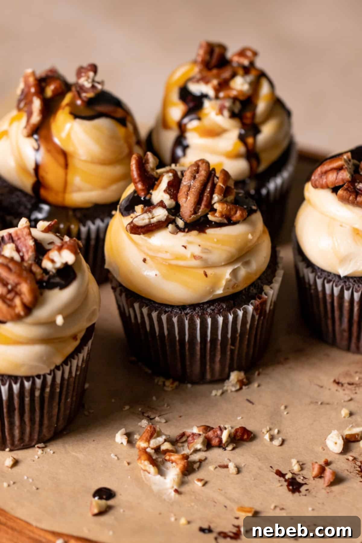 Chocolate turtle cupcakes with caramel swirled buttercream, chocolate ganache, and pecans.