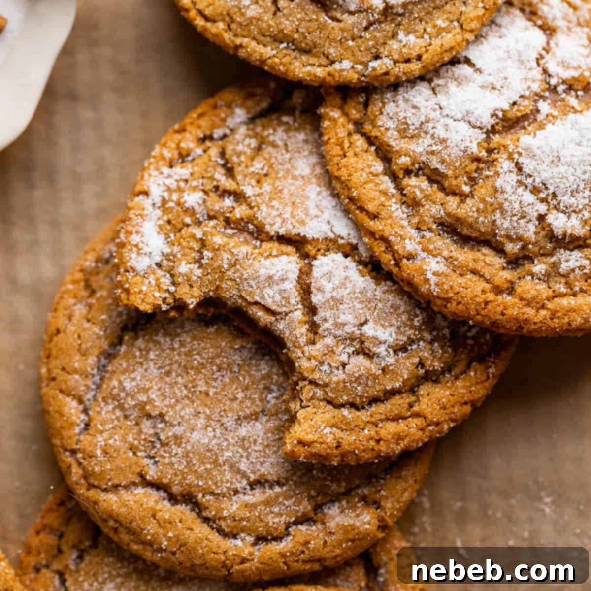 Molasses cookies with crinkle tops on brown parchment paper, freshly baked and delicious.
