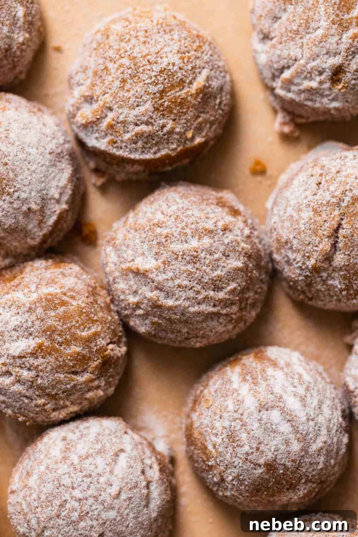Perfectly round molasses cookie dough balls, generously rolled in granulated sugar and neatly arranged on a parchment-lined baking sheet, ready for chilling.