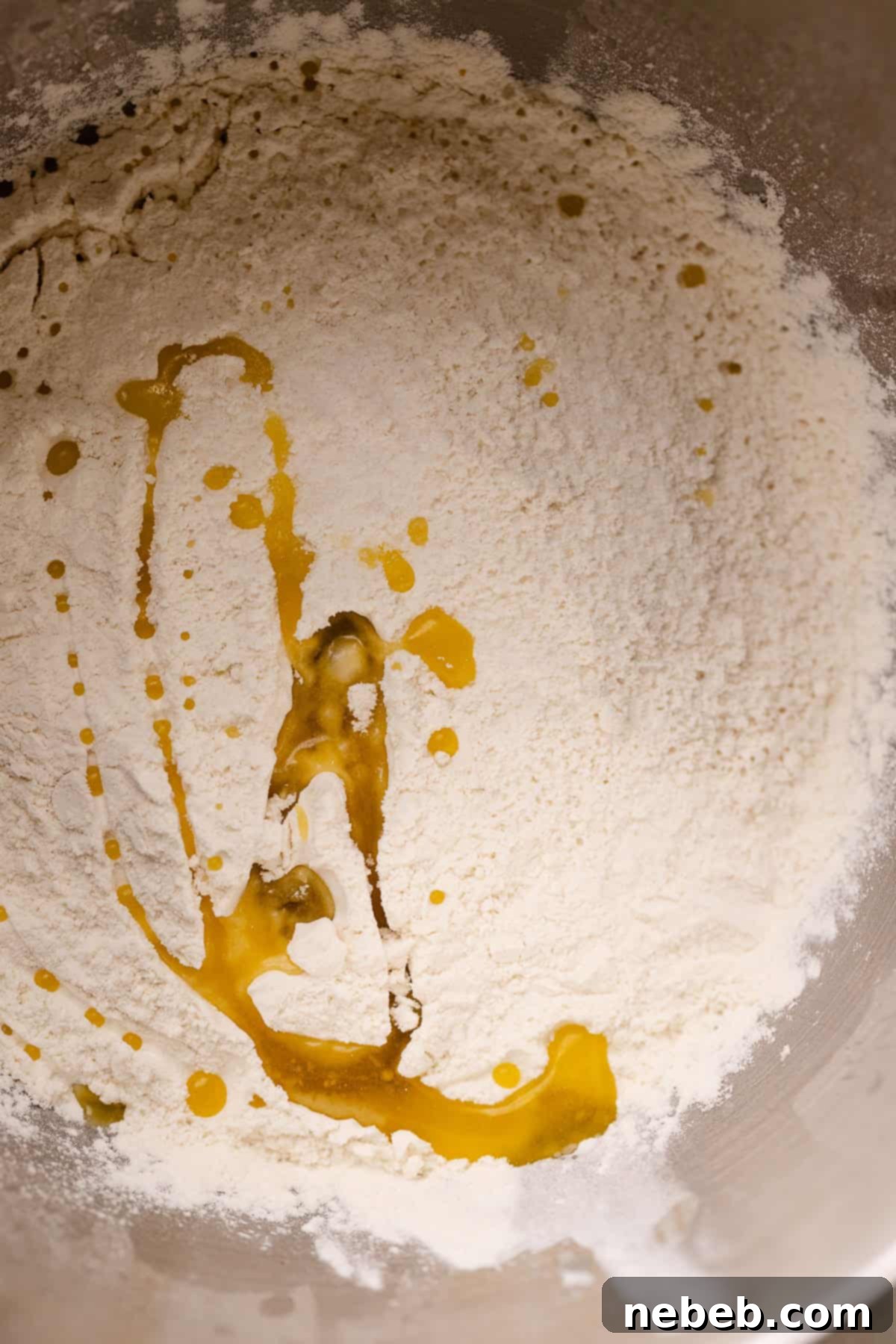 Perfectly Soft and Chewy Homemade Pizza Dough 4 A mixing bowl with the dry ingredients being mixed with the wets to form pizza dough.